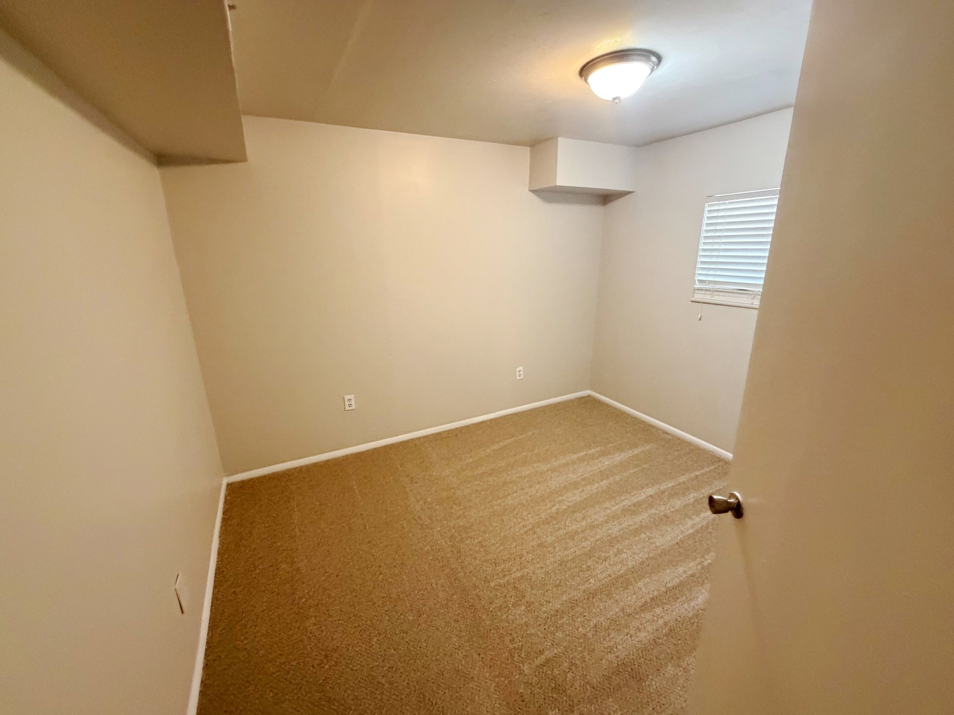 Neutral-toned room featuring wall-to-wall carpeting and perimeter baseboards