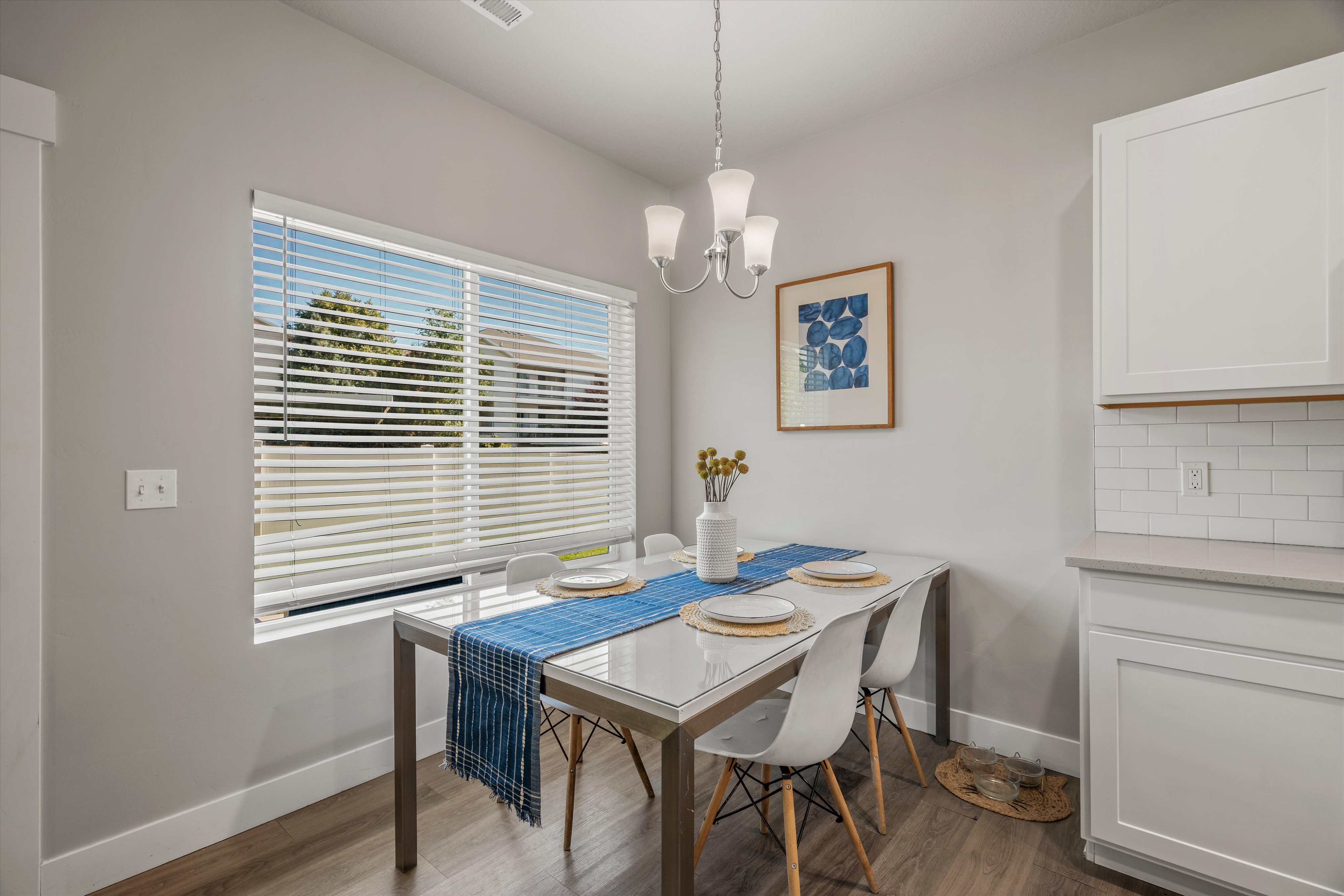 Dining area featuring wood-finish flooring and a contemporary chandelier