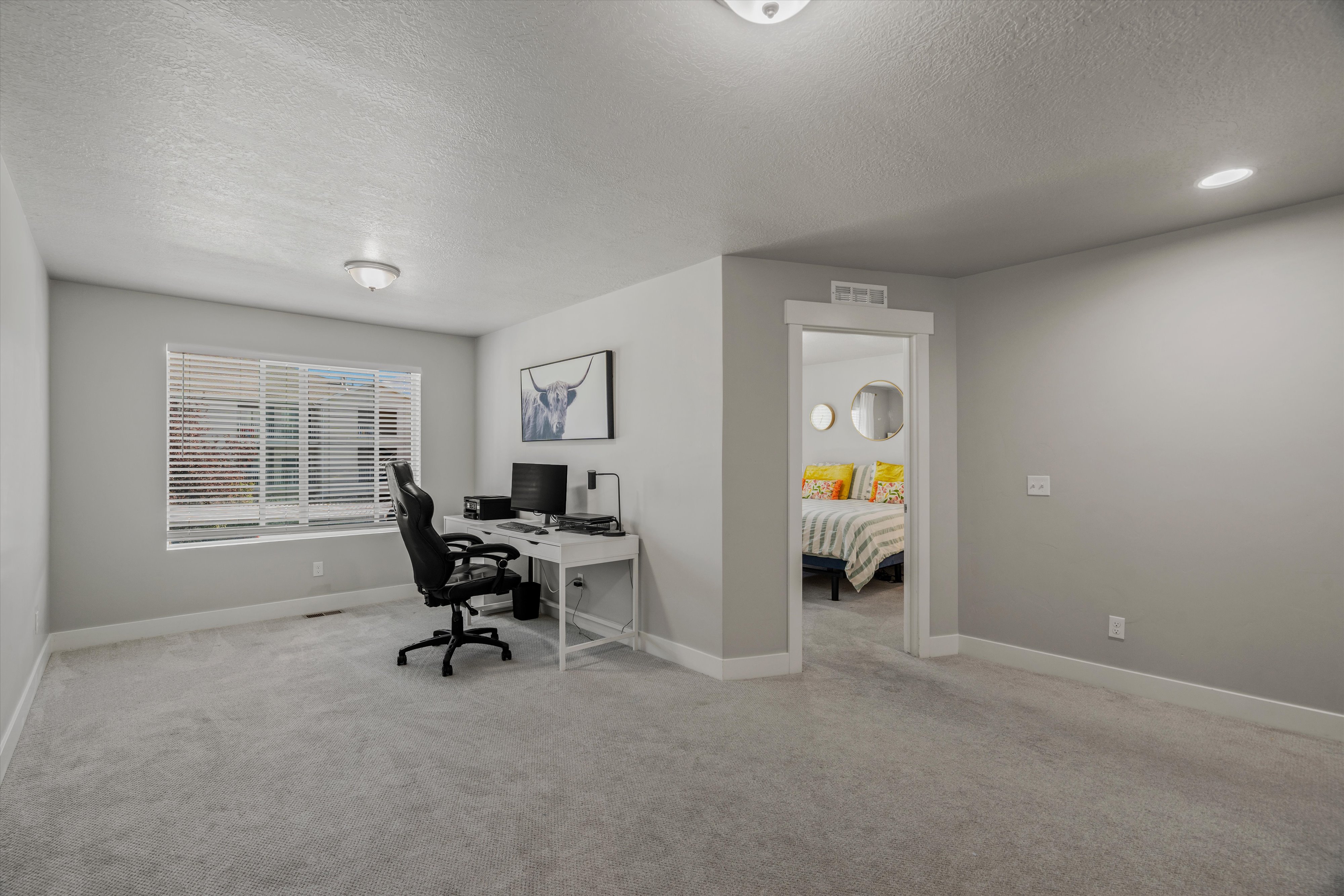 Spacious secondary room with light gray carpeting and white baseboards
