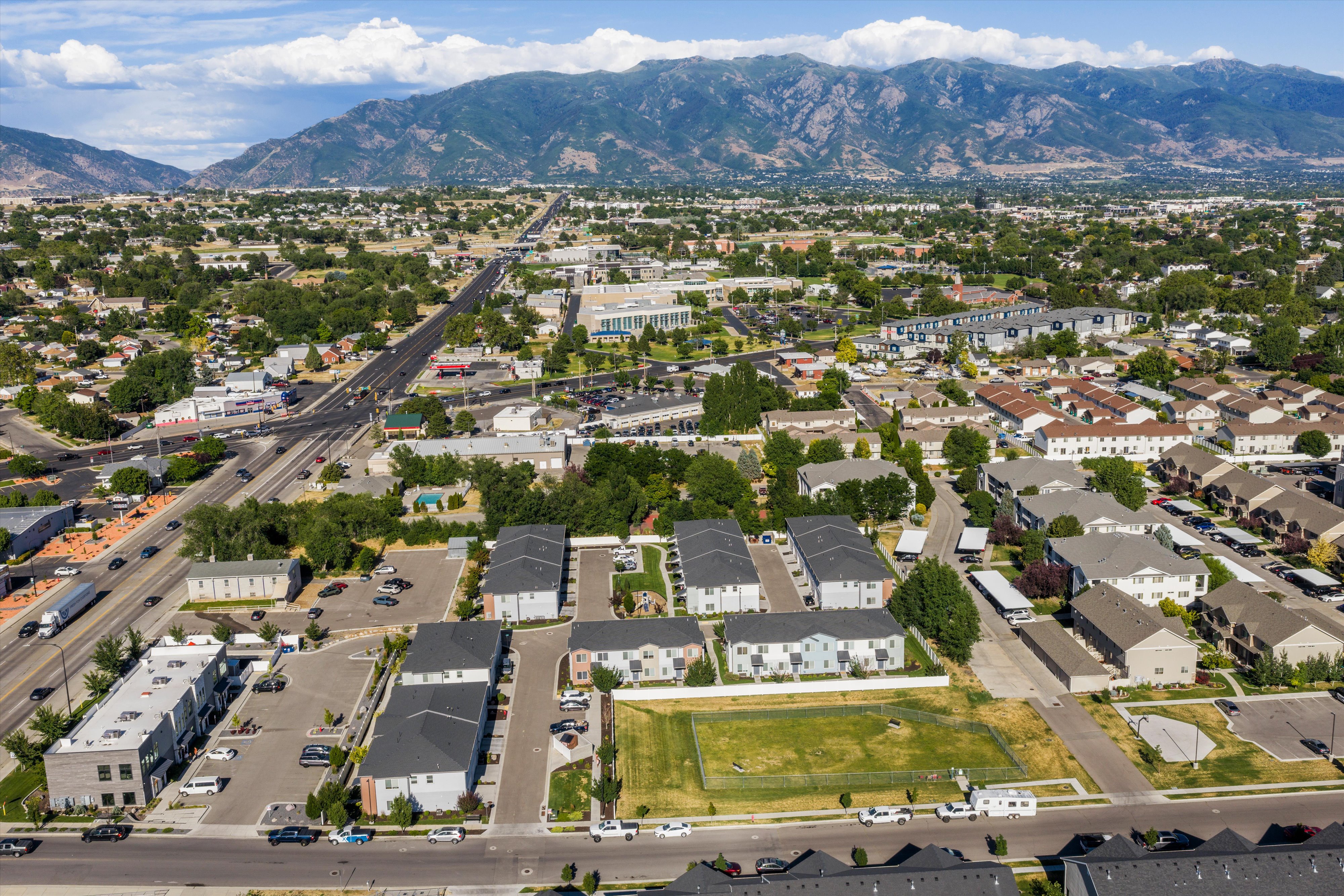 Expansive overhead perspective showcasing a residential and commercial area with mountain backdrop