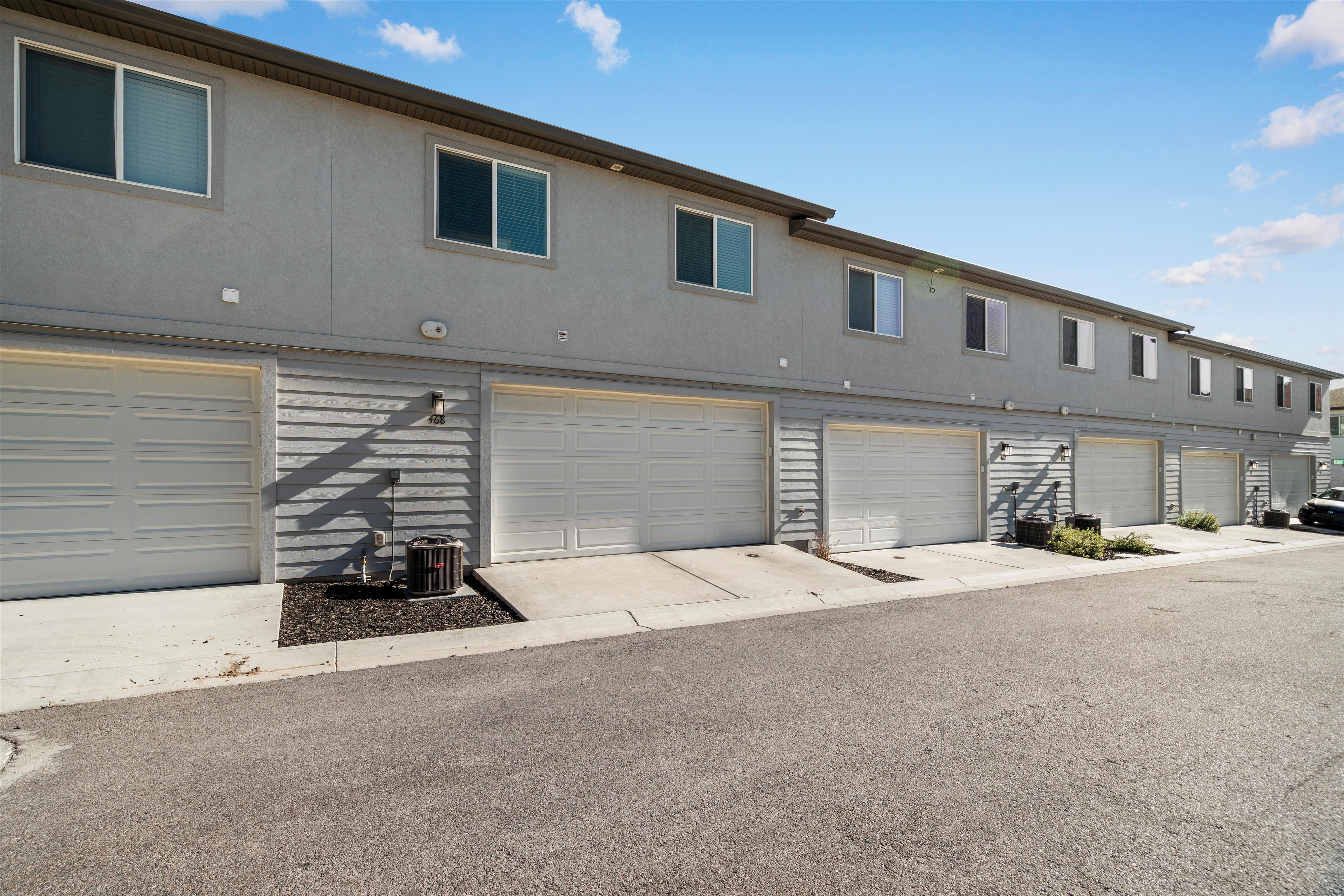 Contemporary townhome-style residences featuring light gray stucco and horizontal siding
