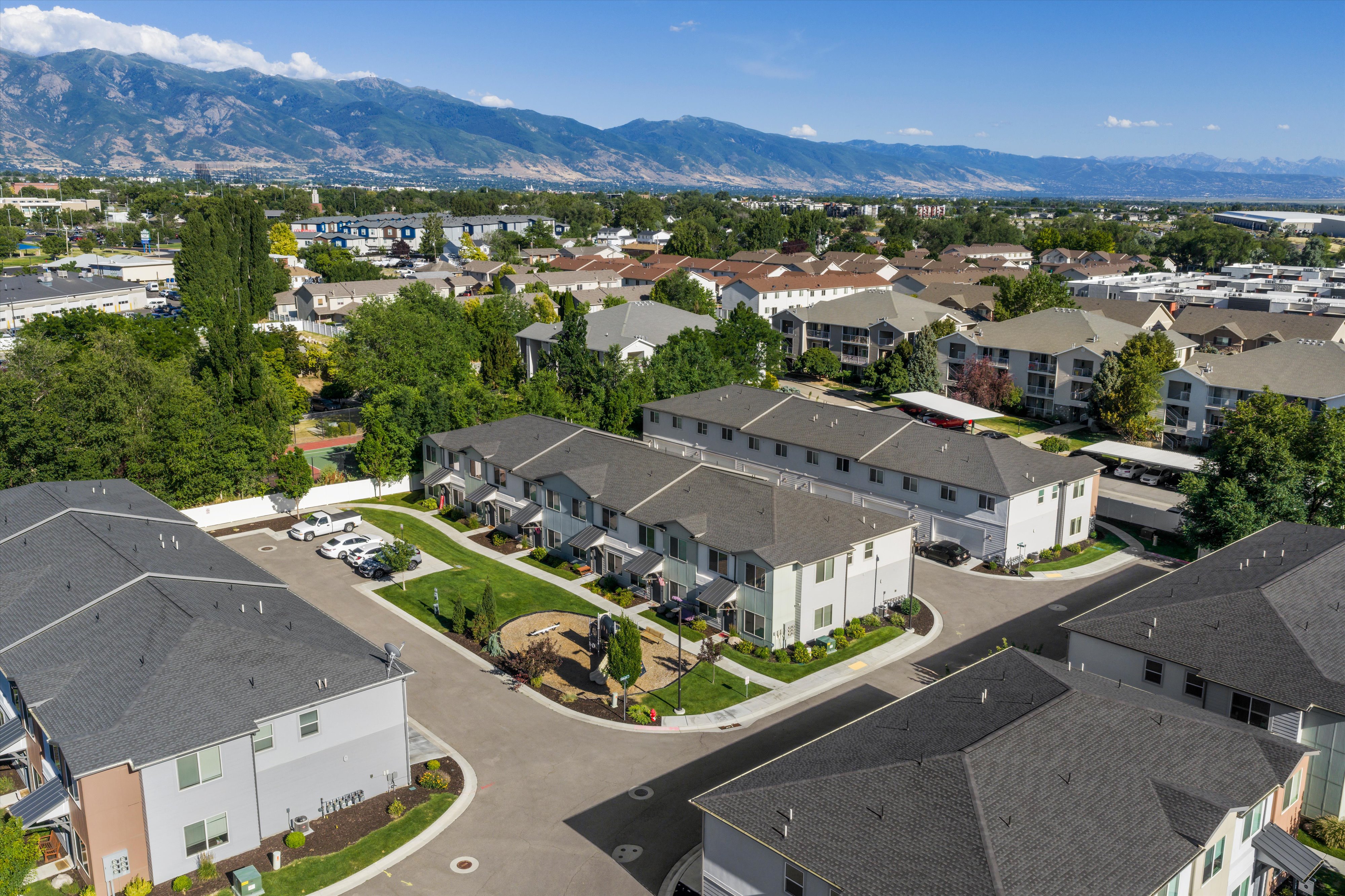 Aerial perspective showcasing multiple townhome-style buildings with gray roofs