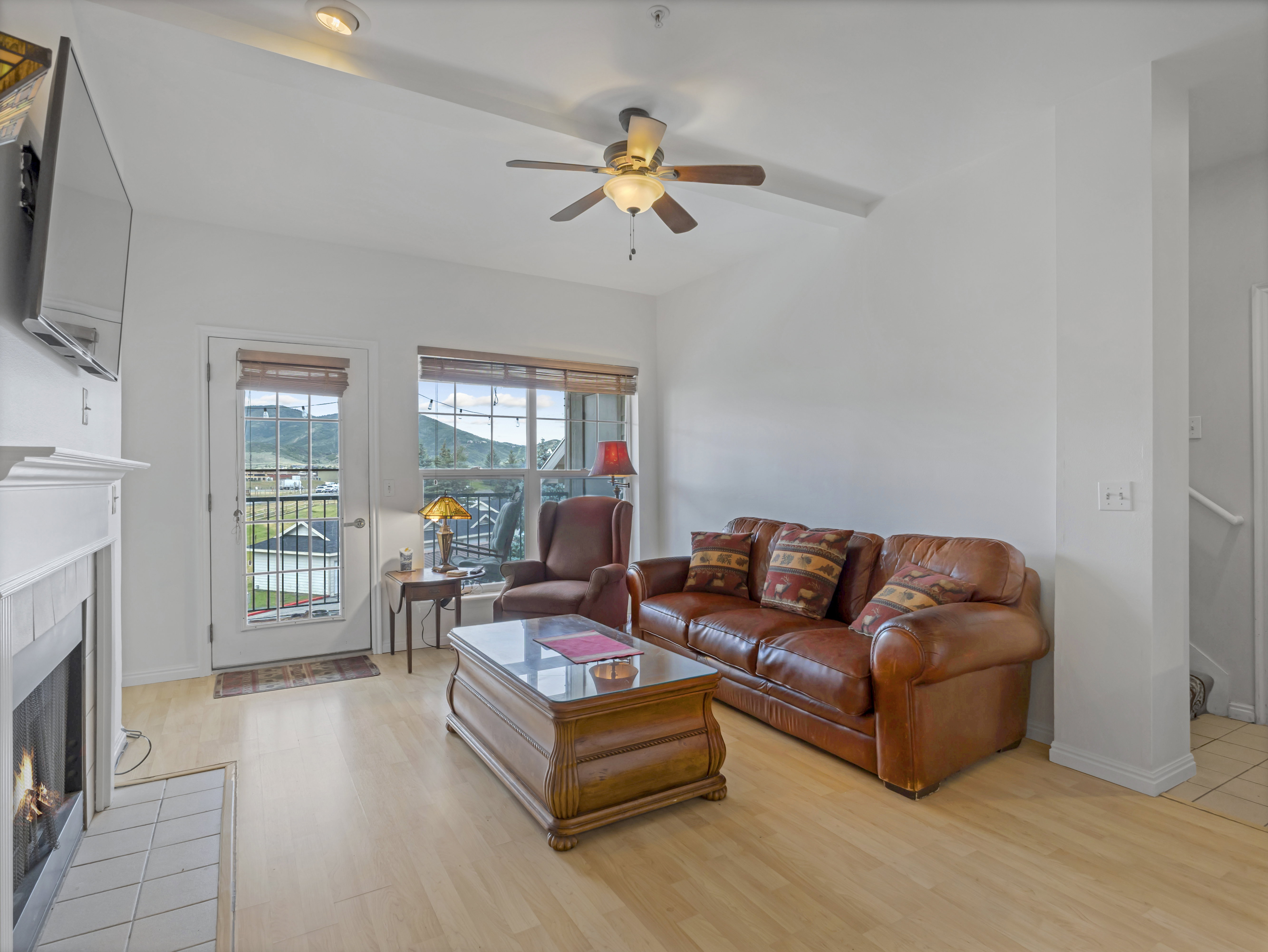 Living area featuring wood-finish flooring and a white painted fireplace with tiled hearth