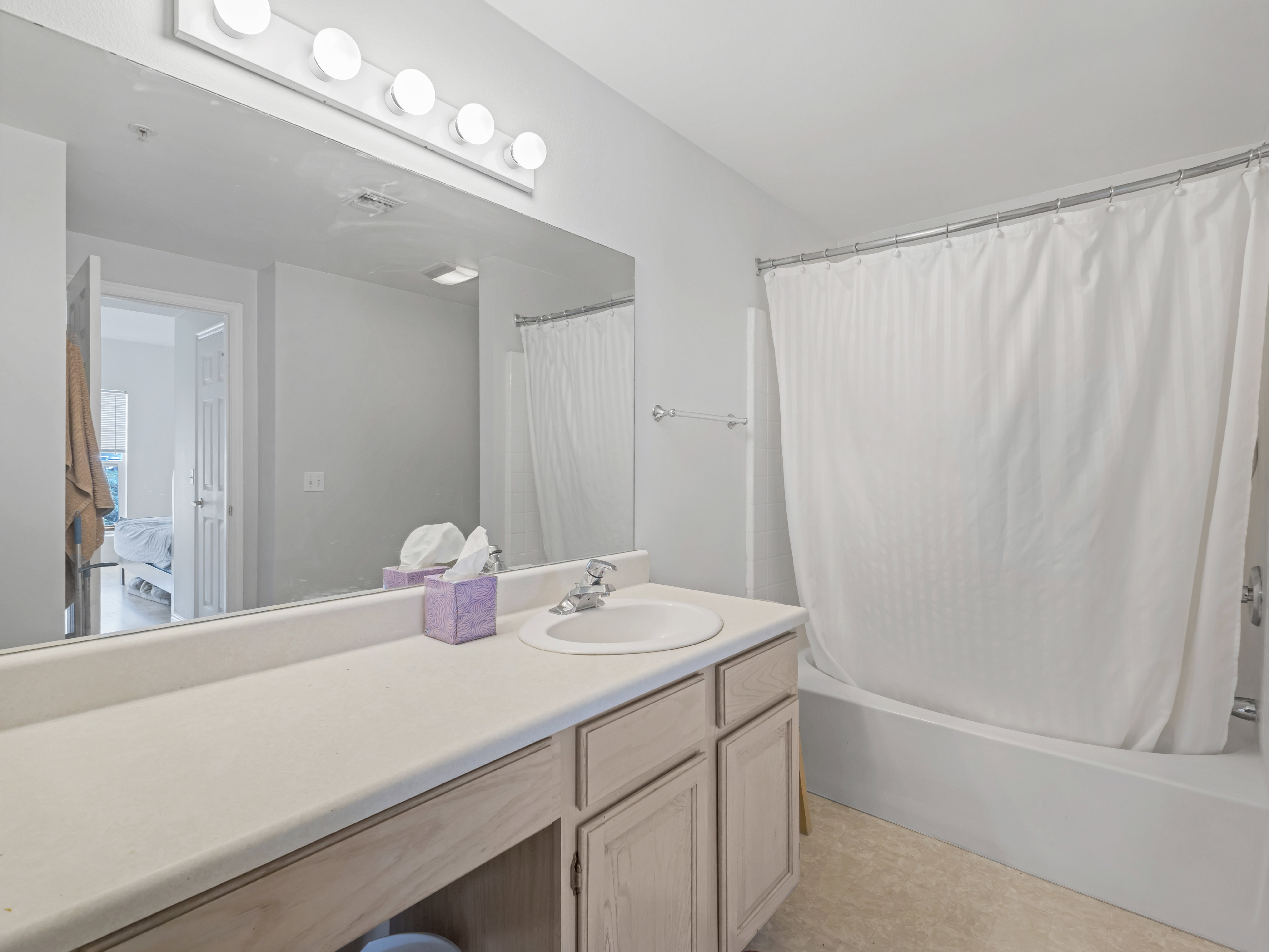 Bathroom featuring a vanity with a light-toned countertop, integrated sink, and wood-finish cabinetry