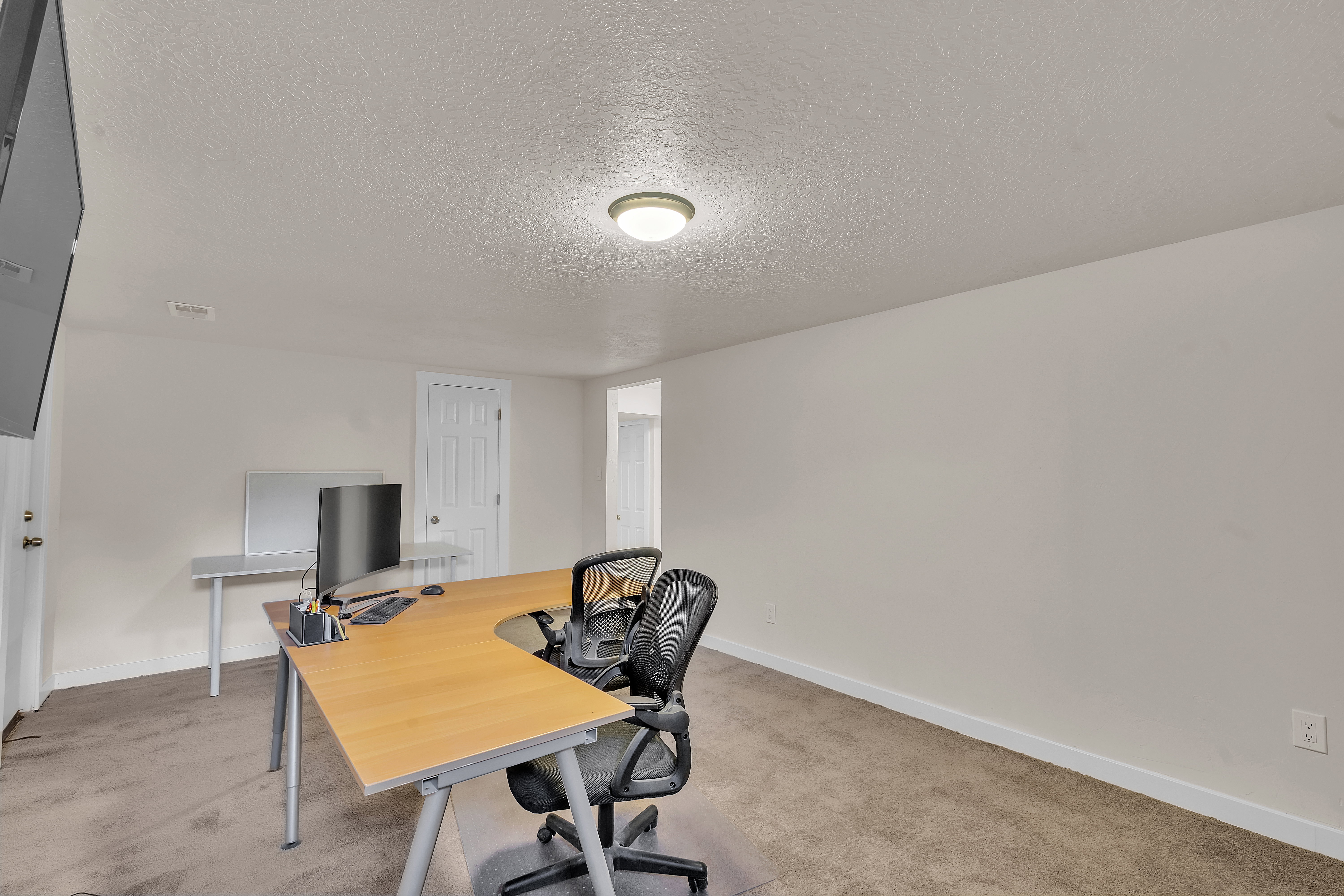 Carpeted room with light-colored walls and a textured ceiling