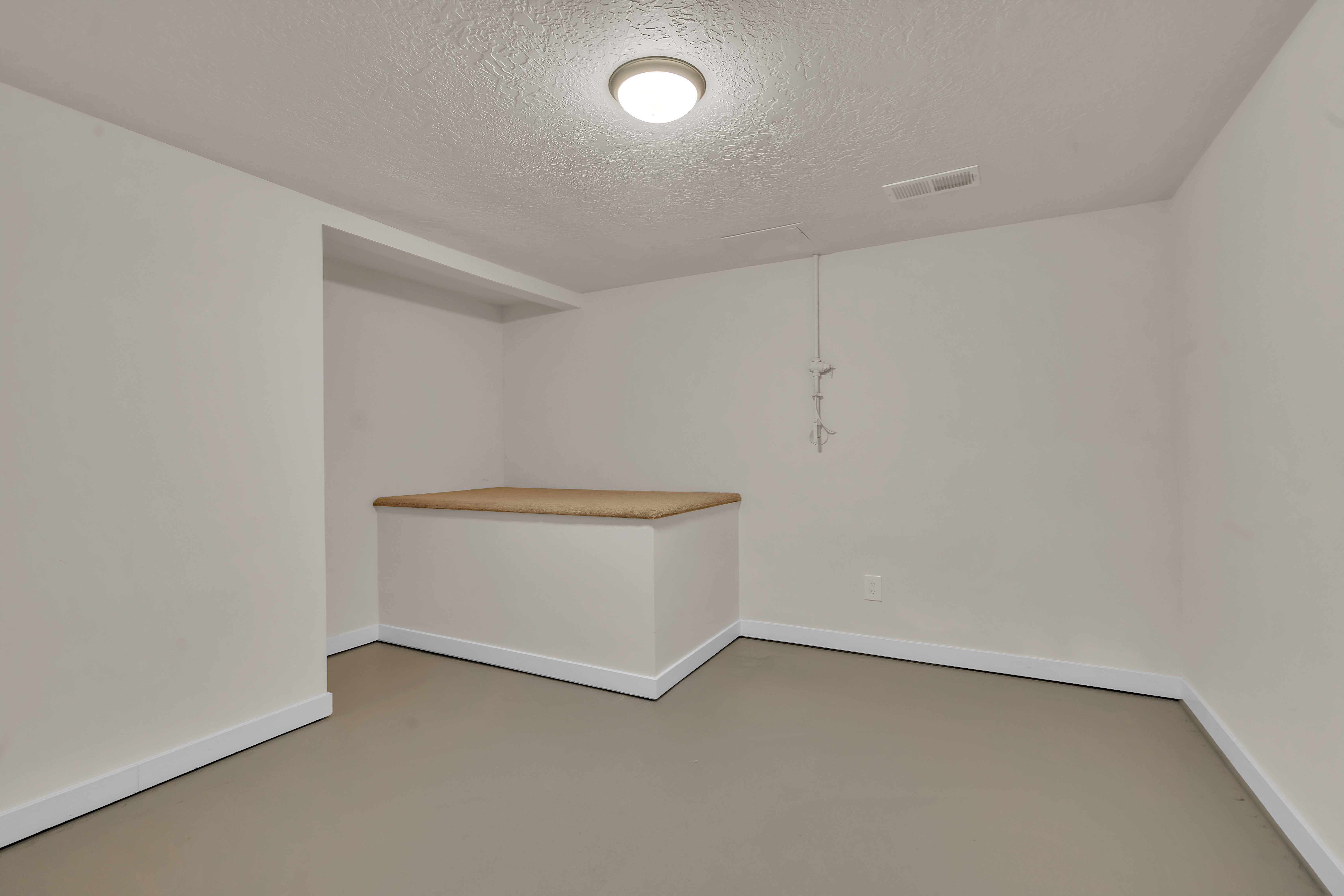 Room featuring light-toned walls, a neutral floor finish, and white baseboards