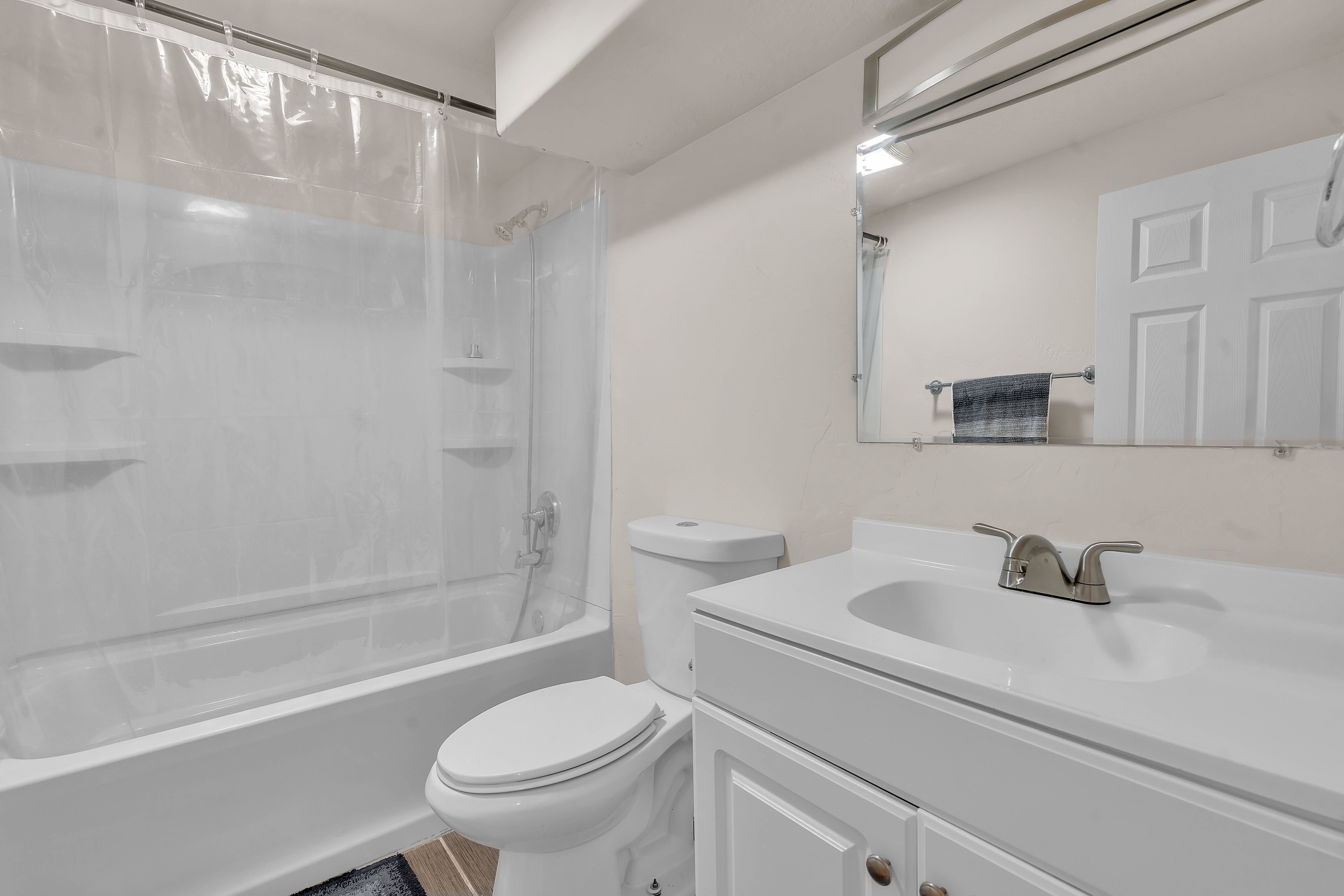 Bathroom featuring a white vanity with a single basin sink, brushed nickel faucet, and under-sink storage