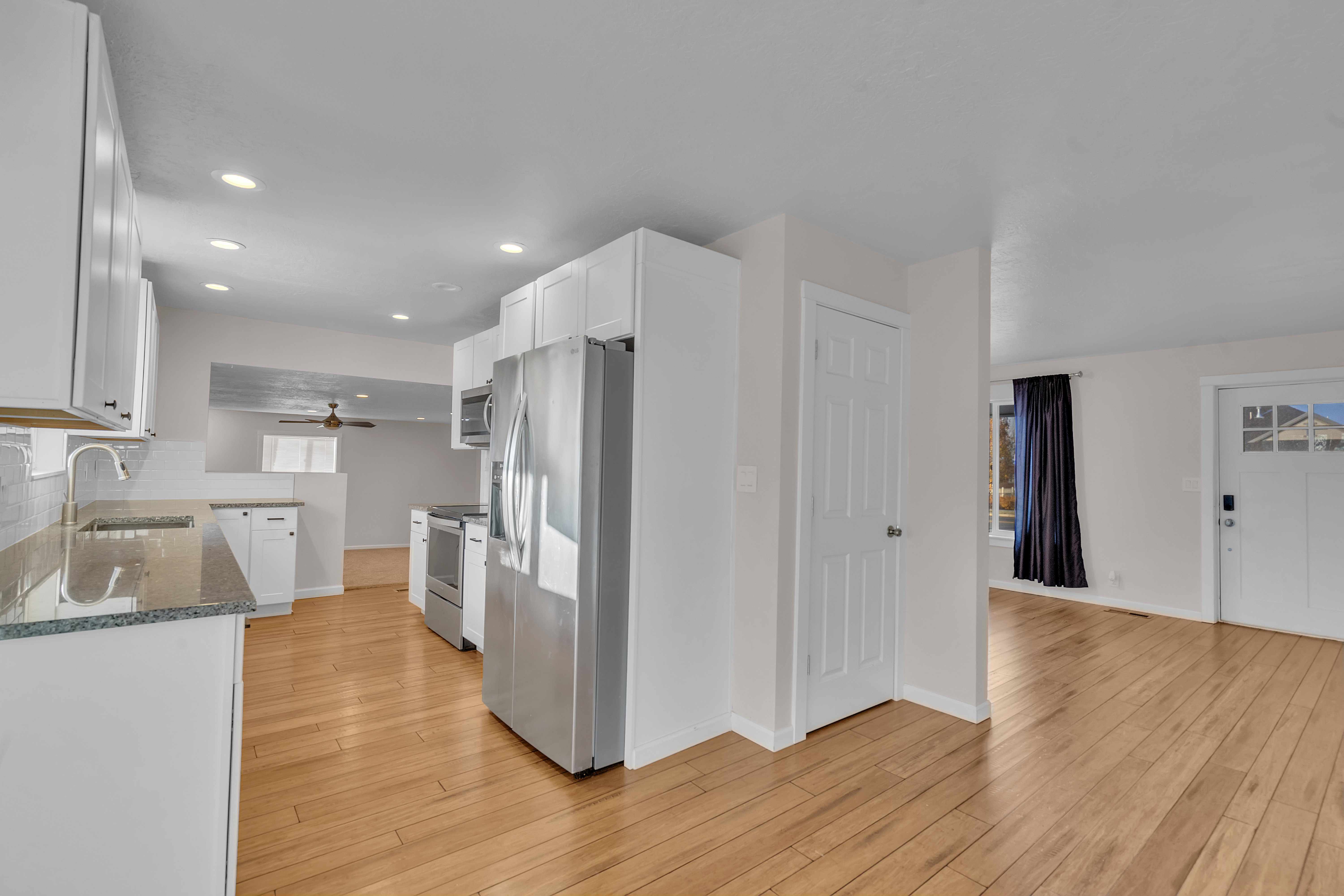 Kitchen featuring light wood-finish flooring, white cabinetry, stainless steel appliances, and recessed lighting