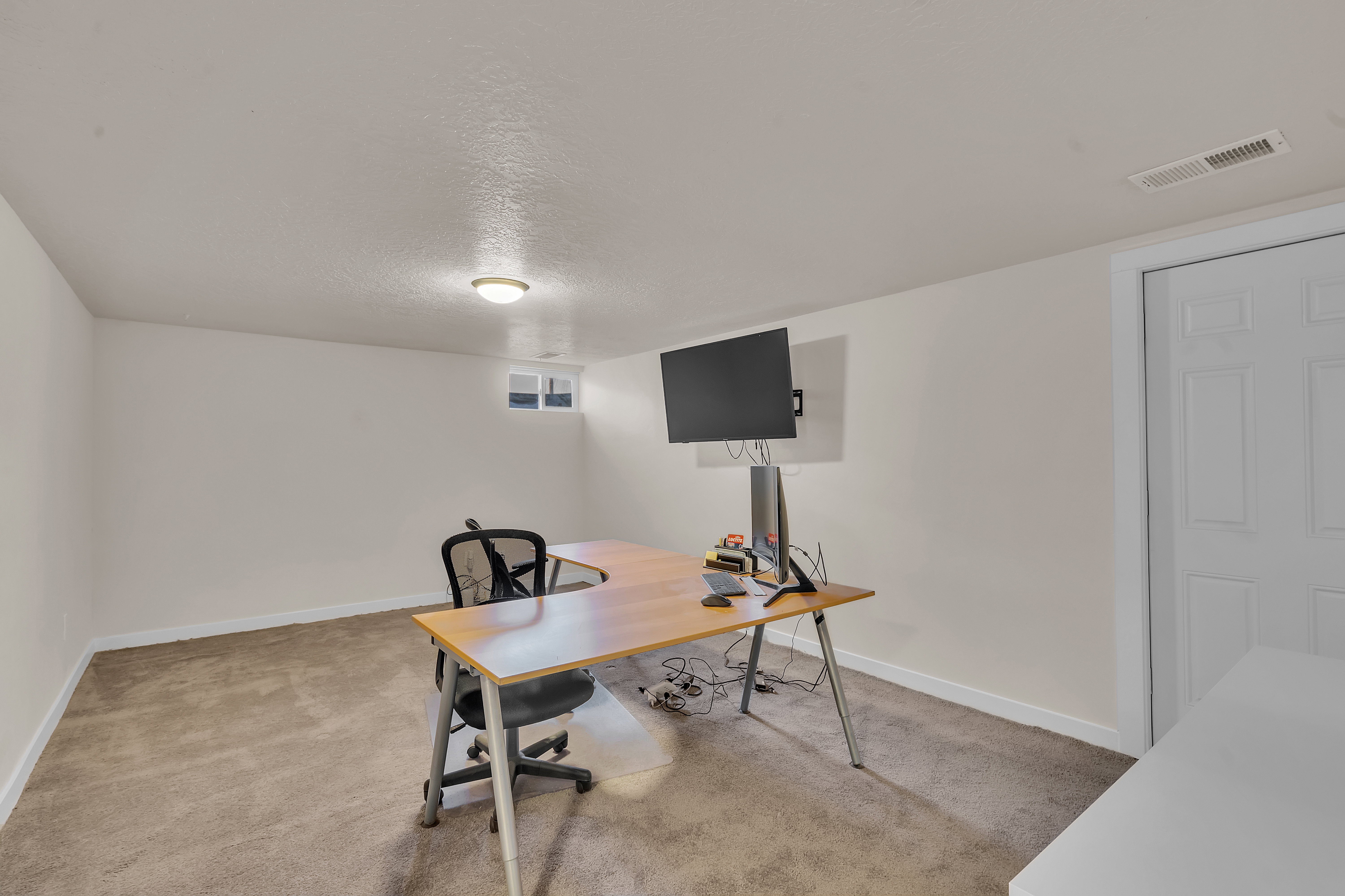 Versatile room featuring light neutral wall tones, low-pile carpeting, and a white six-panel door