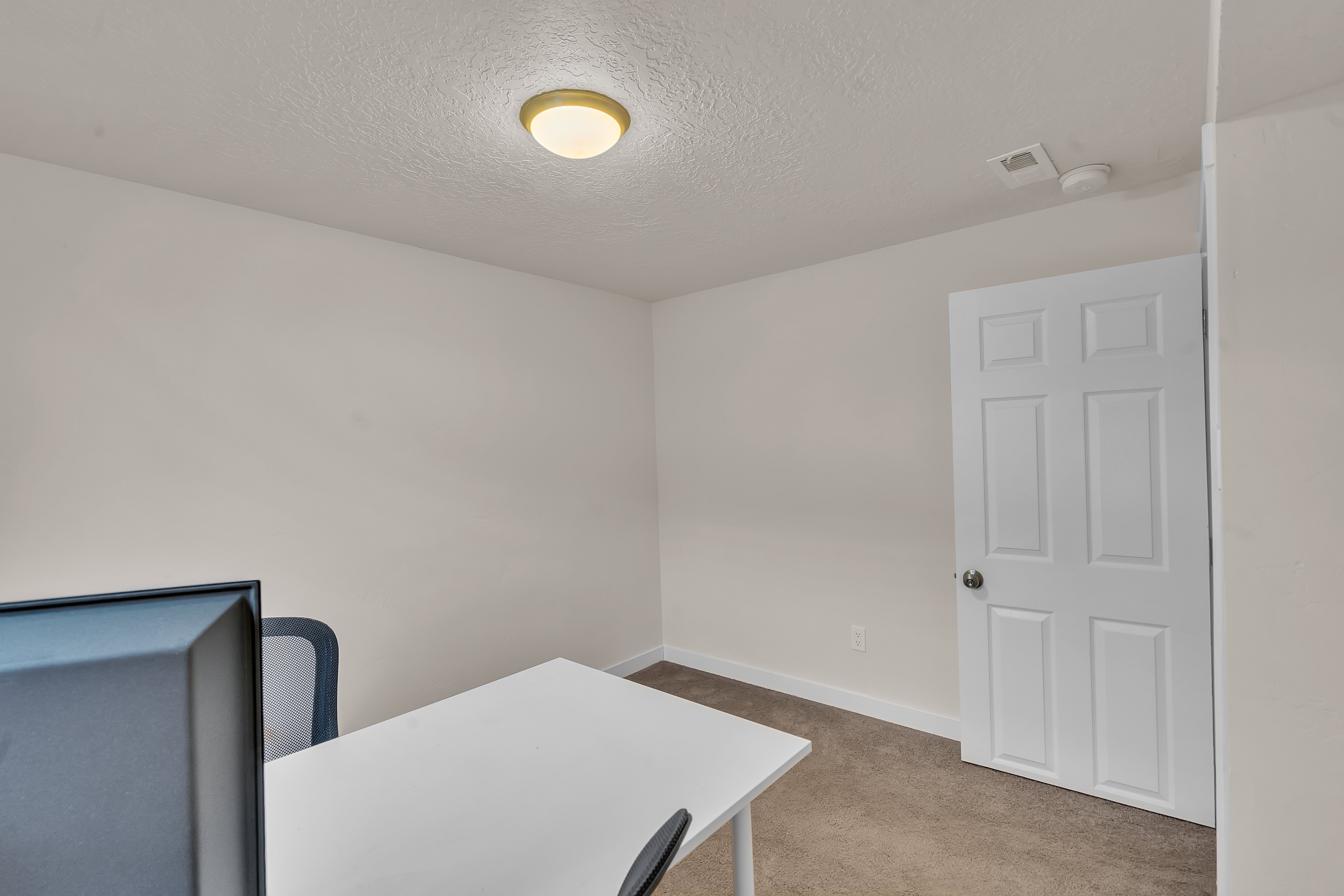 Interior room with neutral wall color, textured ceiling, and a simple ceiling-mounted light fixture