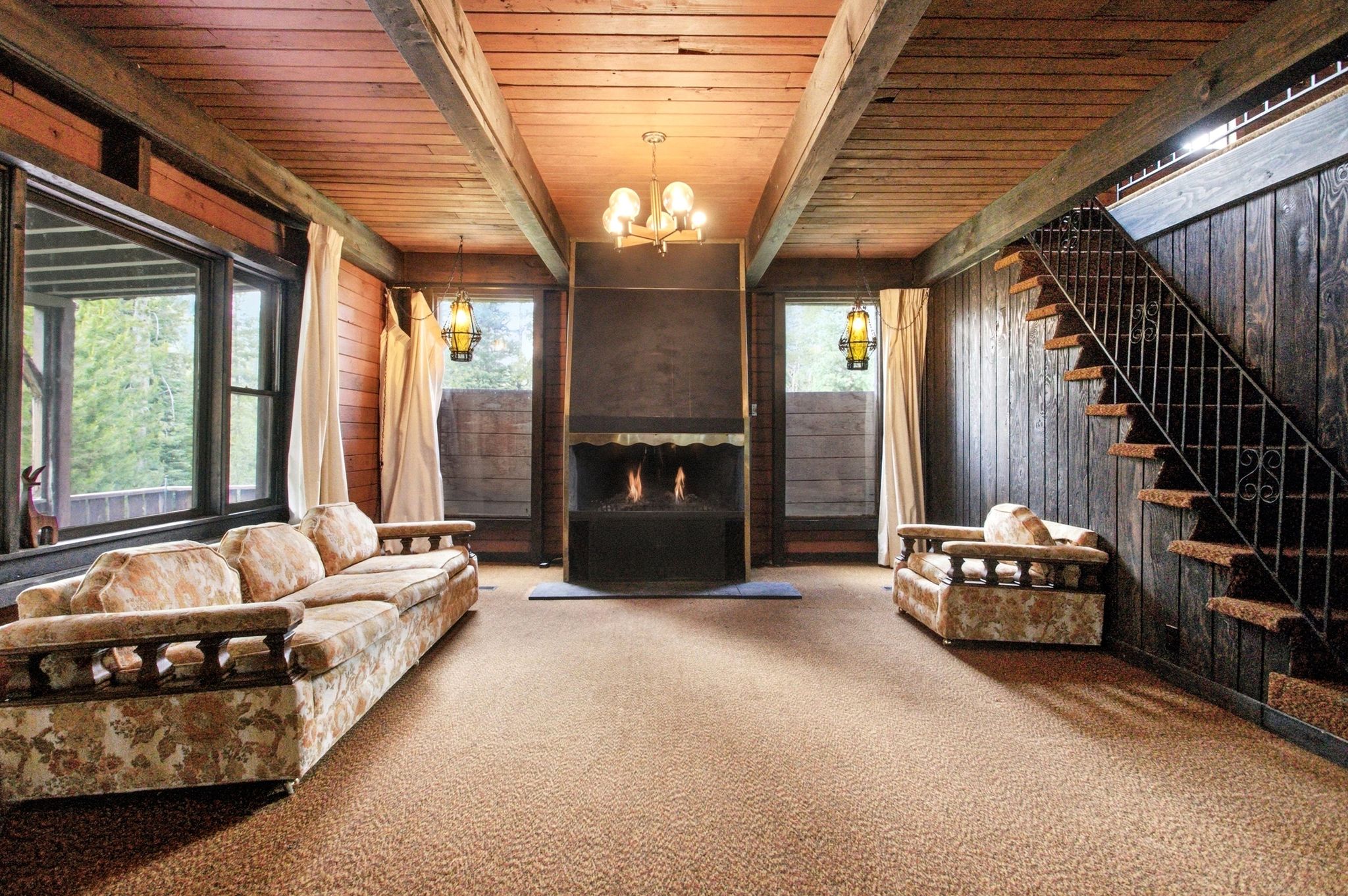 Spacious interior with exposed wood beam ceilings and wood-paneled walls