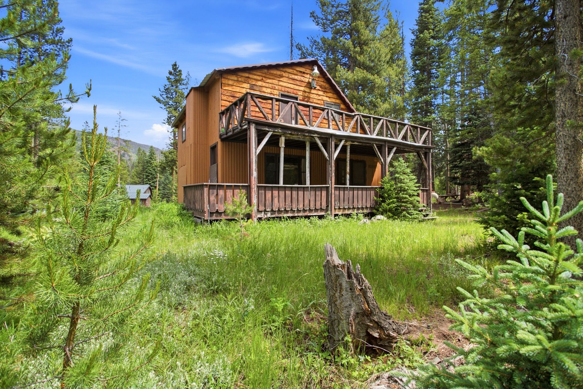 Rustic-style dwelling featuring a gabled roof and an upper-level balcony