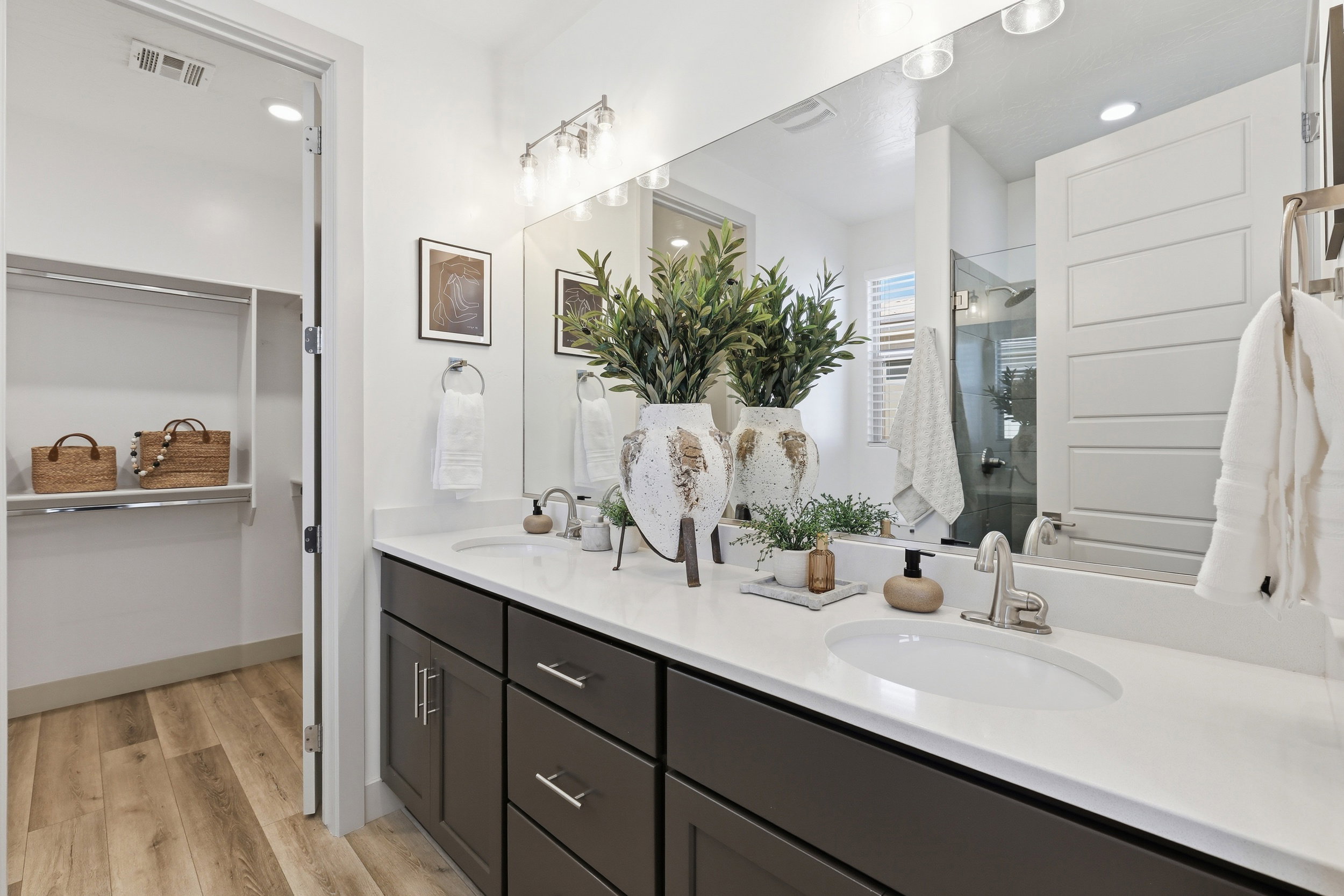 Dual vanity with white undermount sinks and brushed nickel faucets, set in a white countertop over dark wood cabinetry