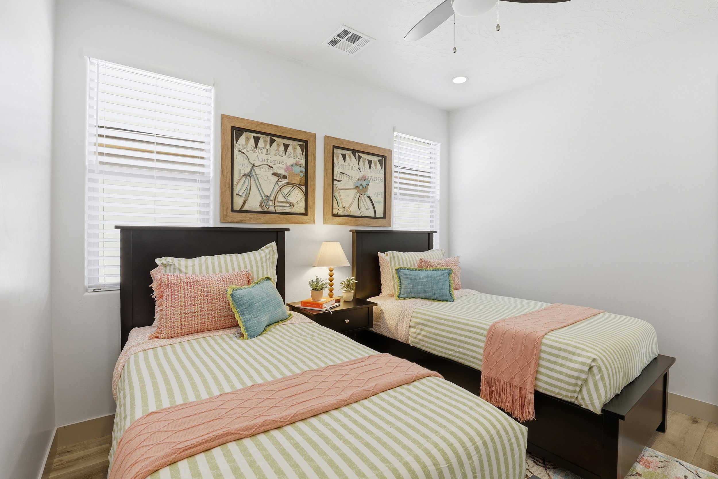Spacious bedroom featuring light-colored walls, wood-finish flooring, a contemporary ceiling fan, and recessed lighting