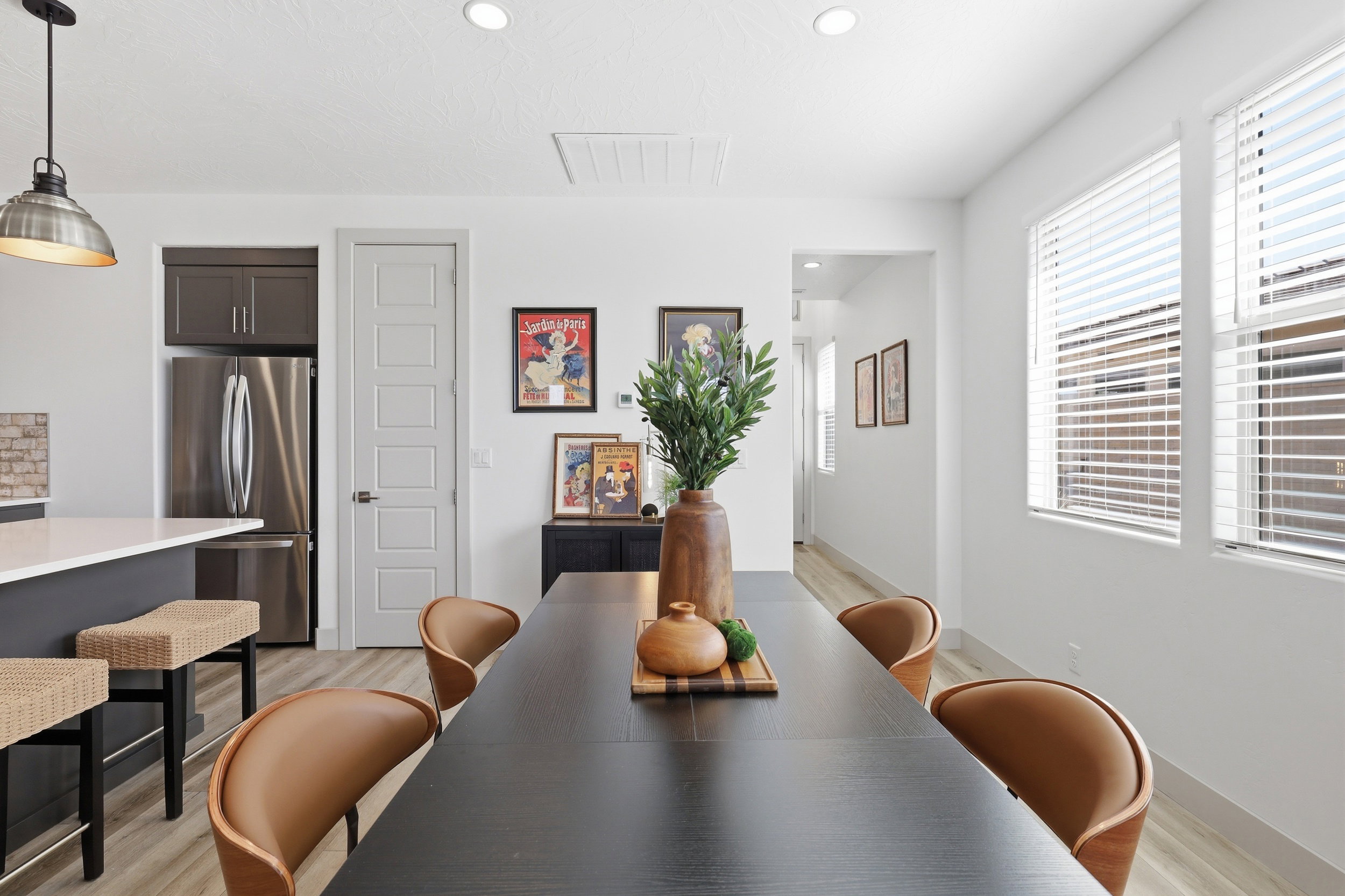 Open-concept dining area featuring wood-finish flooring, recessed lighting, and a modern pendant light fixture