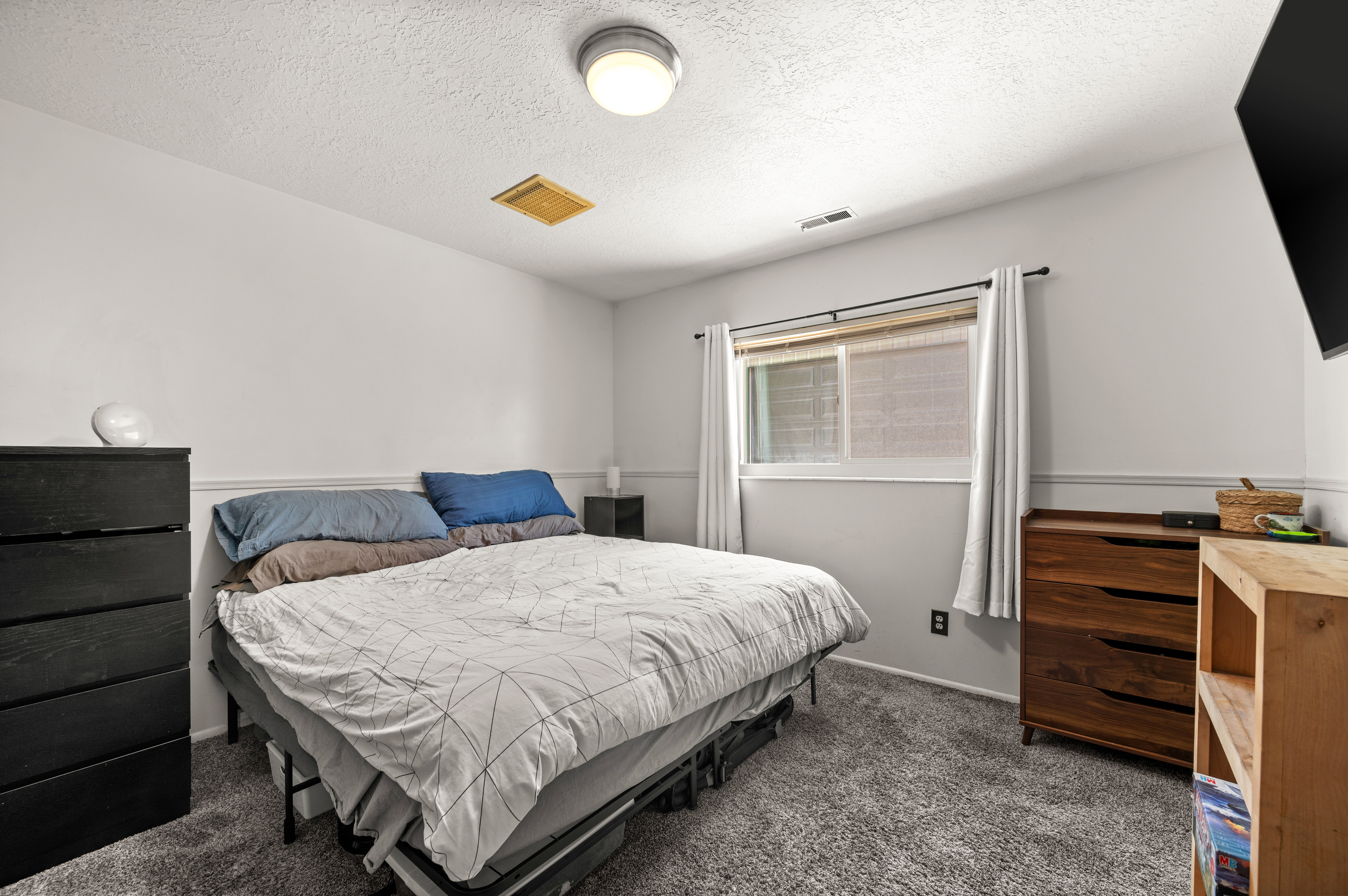Carpeted room with a textured ceiling and recessed lighting