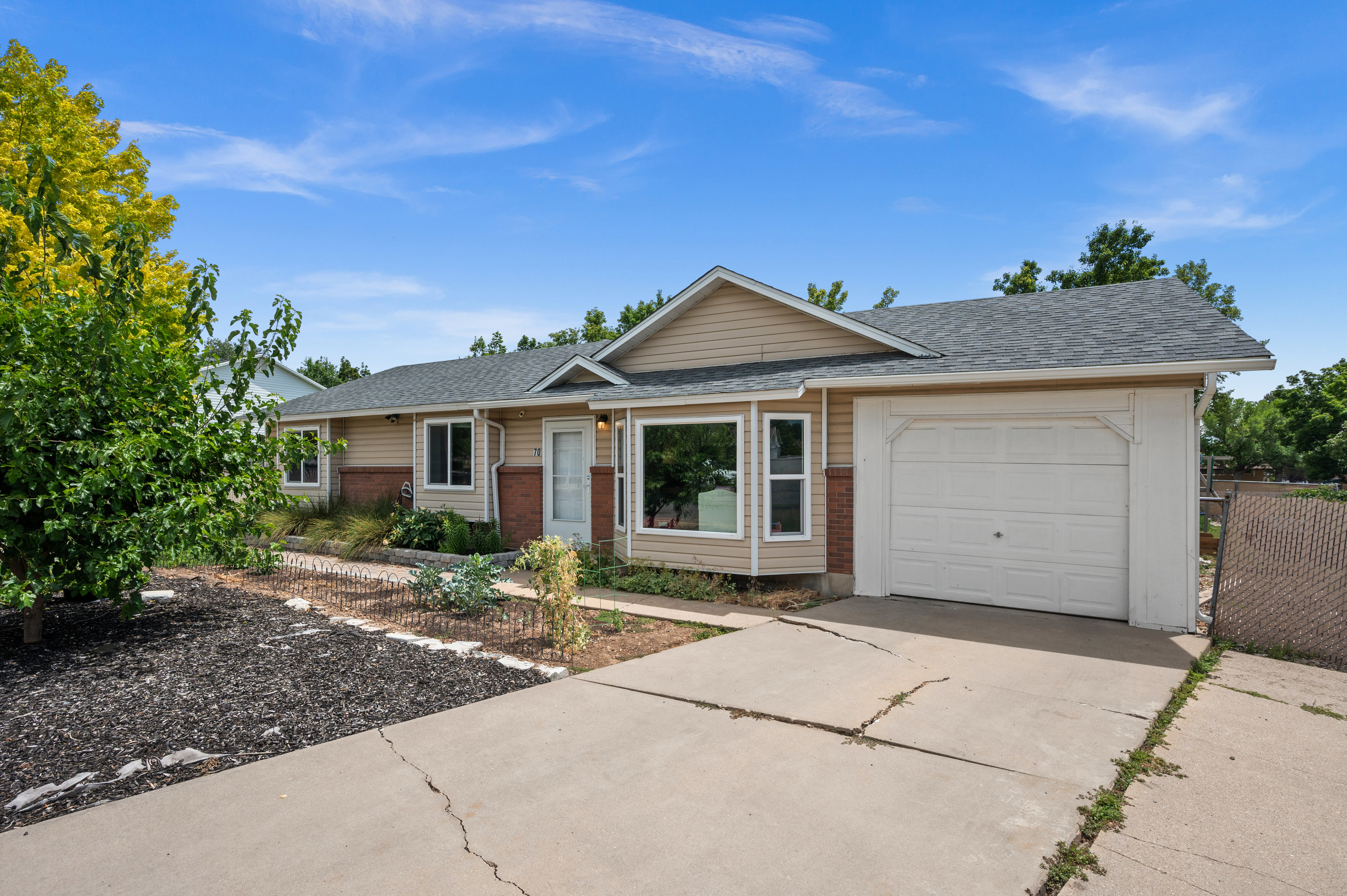 Ranch-style exterior featuring light-toned siding and brick veneer accents