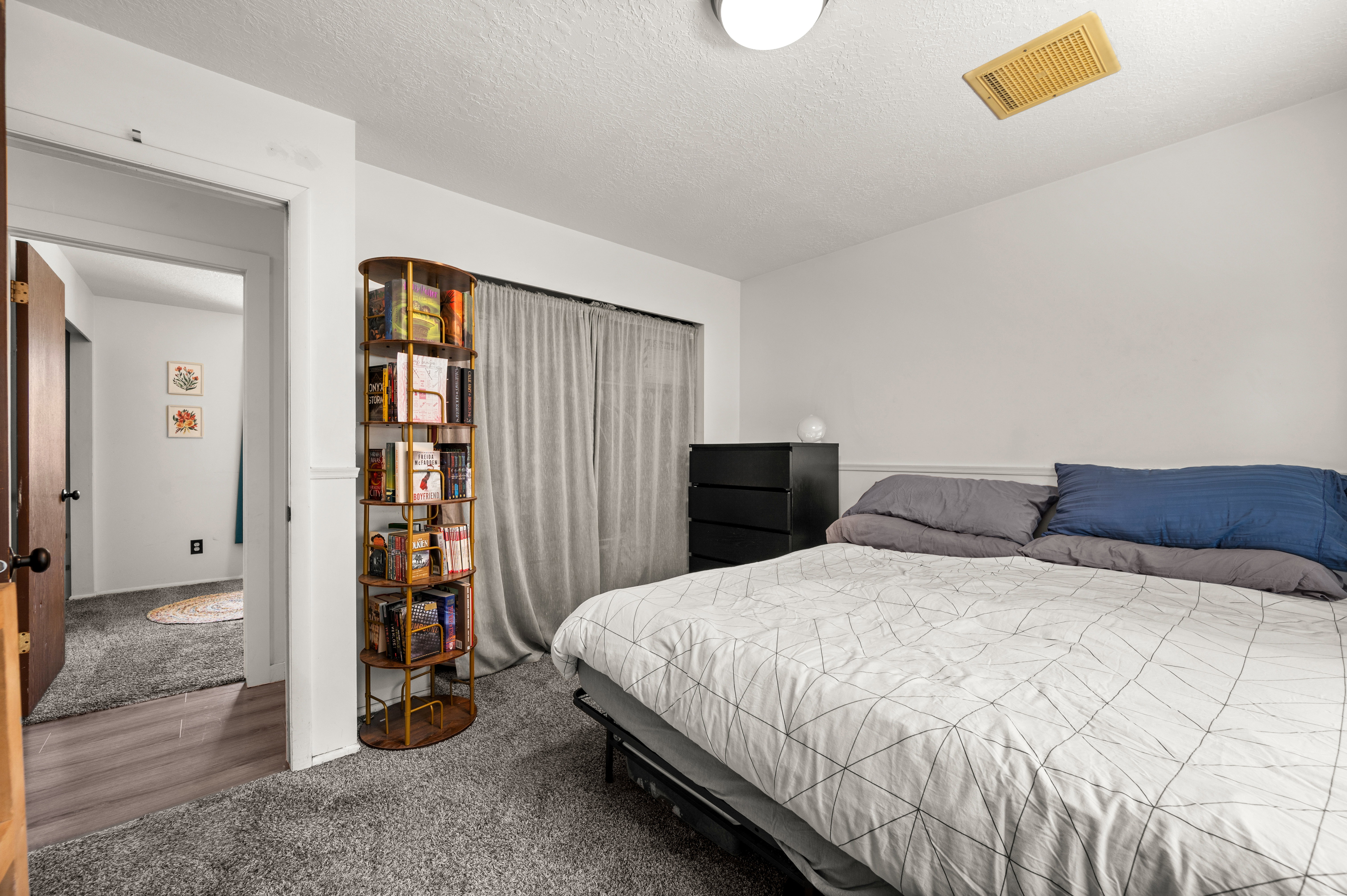 Carpeted room with white walls, a built-in shelf, and ceiling-mounted light fixture