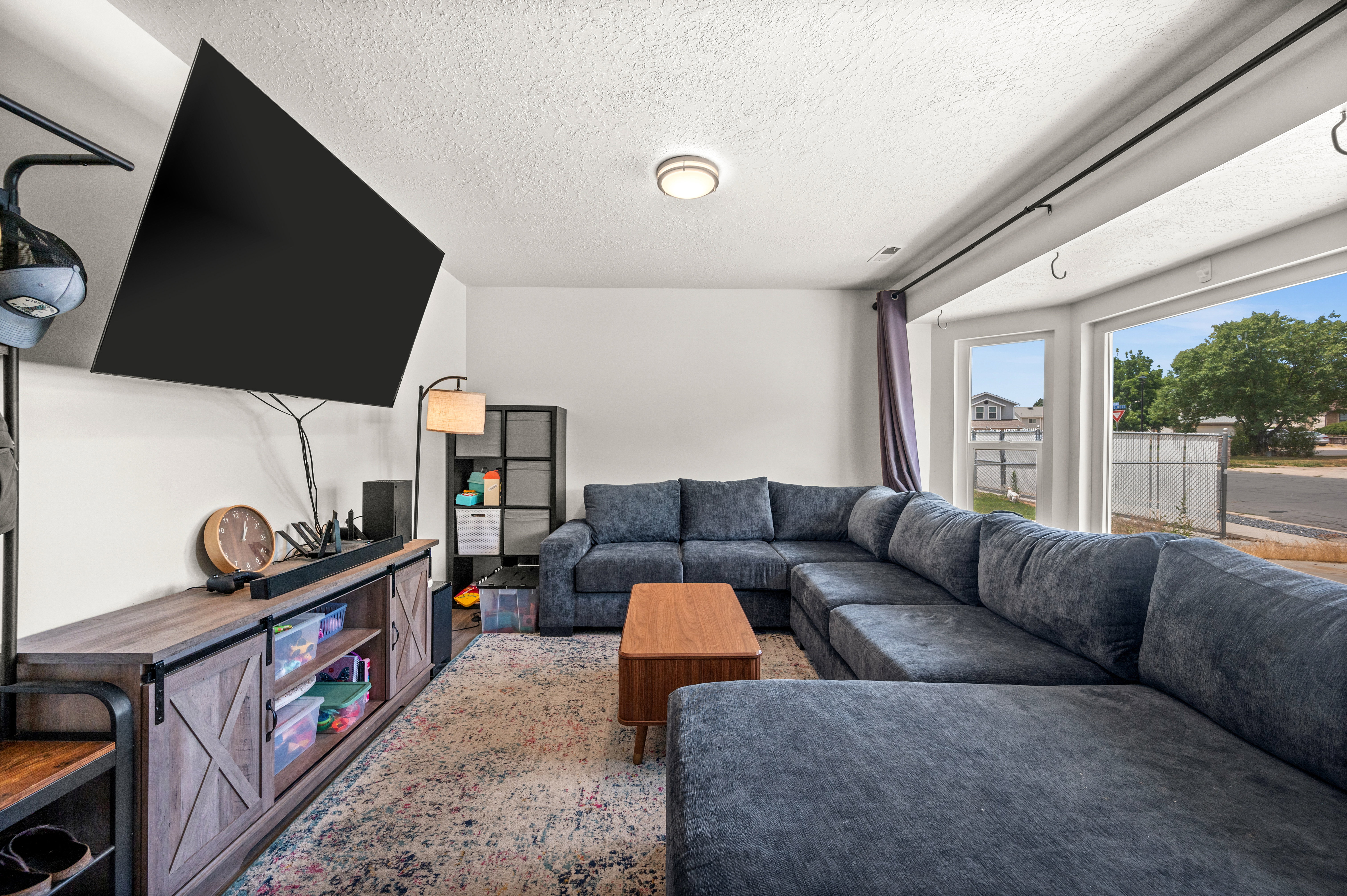 Living area featuring a large bay window, recessed lighting, and a built-in media console with barn door accents