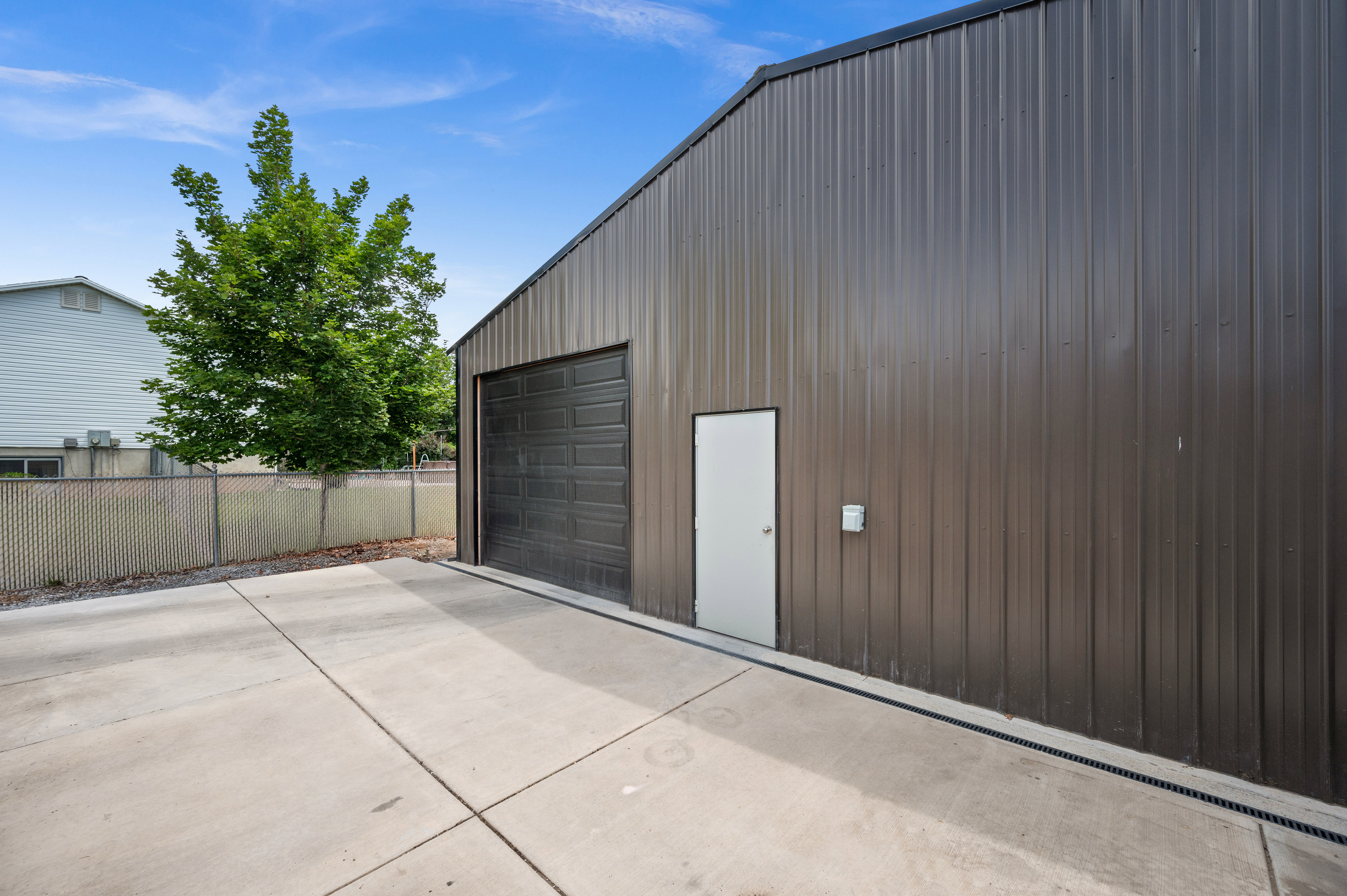 Metal-sided outbuilding with an overhead garage door and a separate entry door