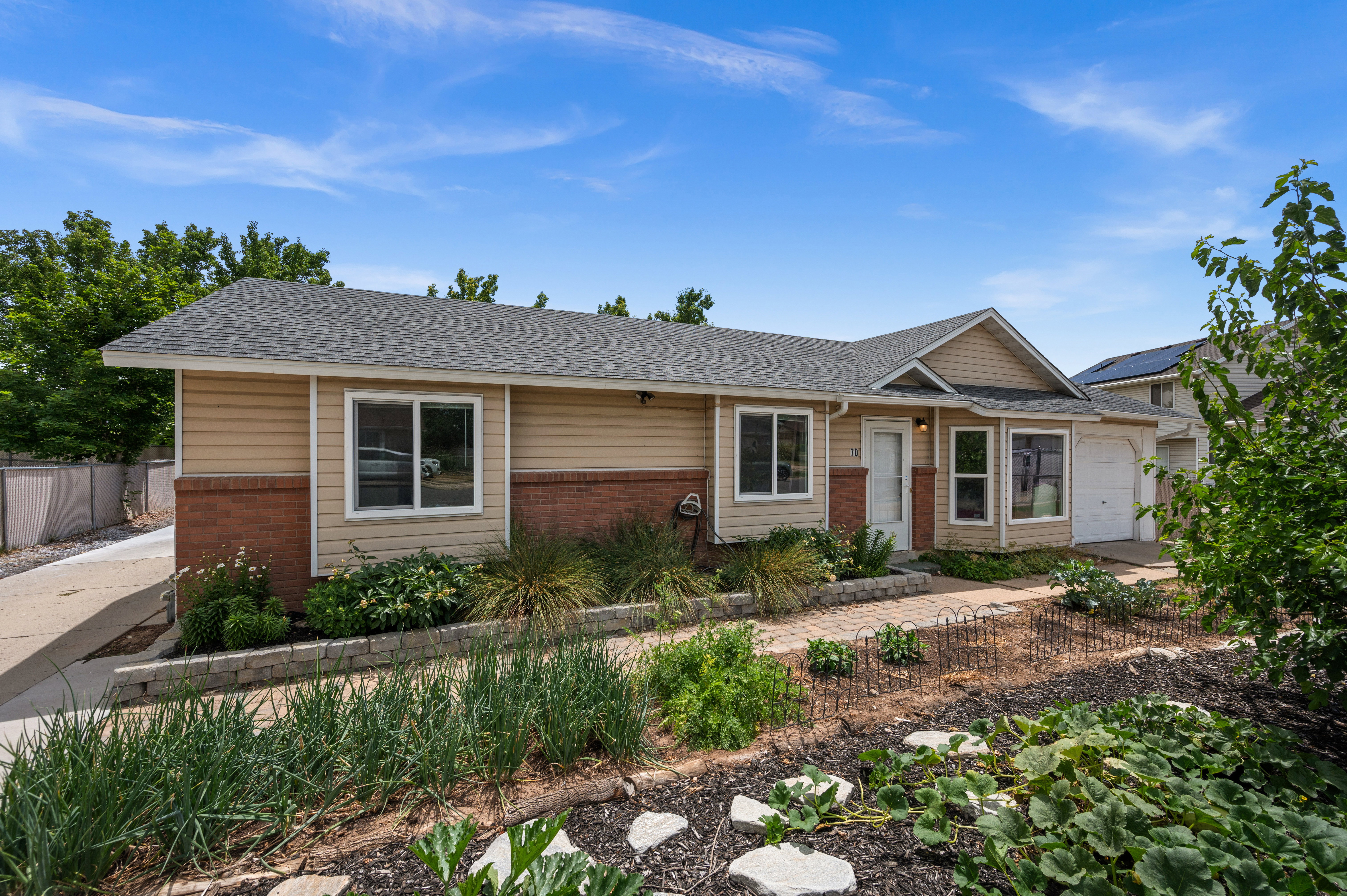Ranch-style exterior with tan siding and brick accents