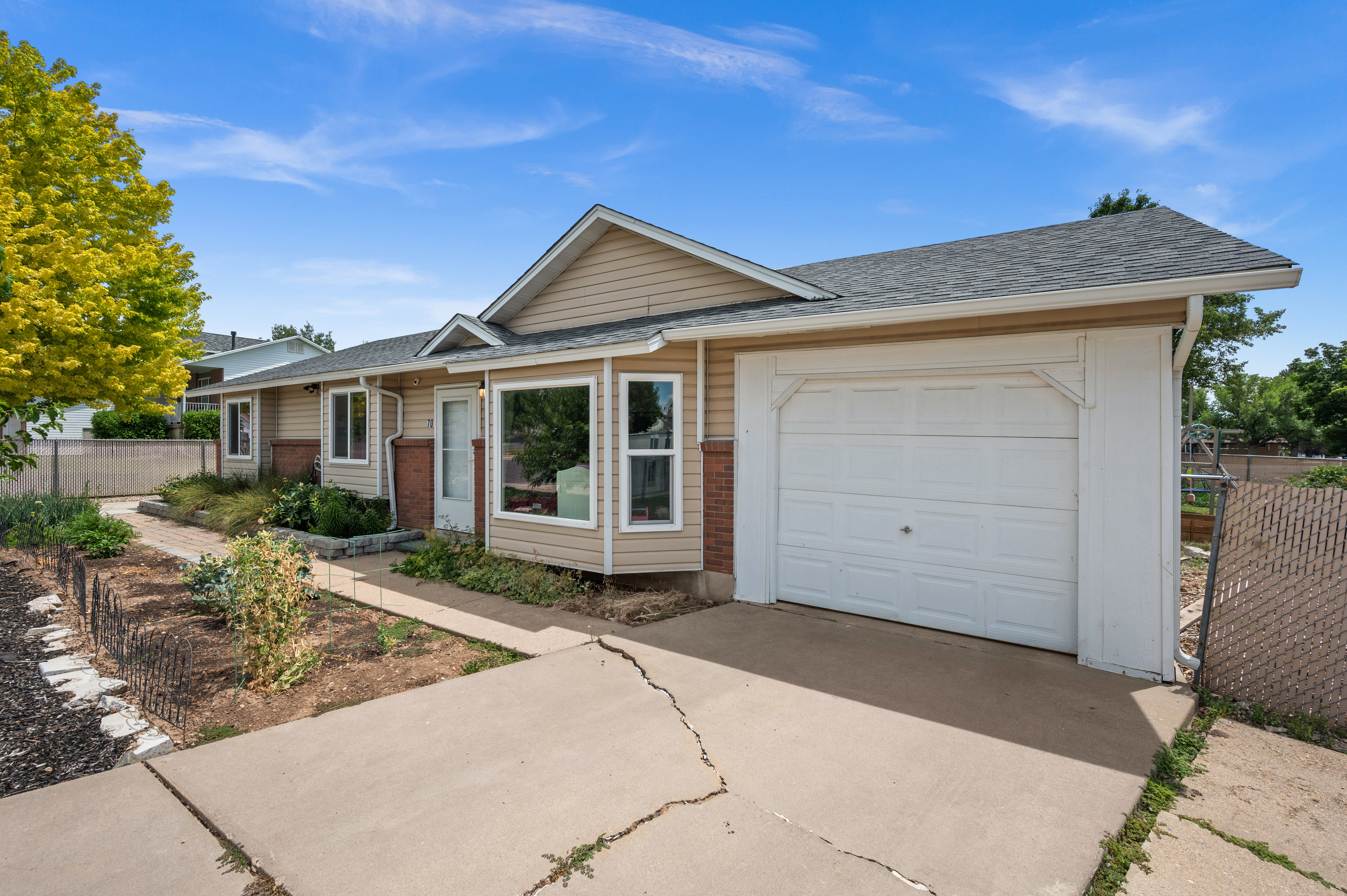 Exterior featuring beige siding, a dark shingle roof, and a single-car garage with a white door