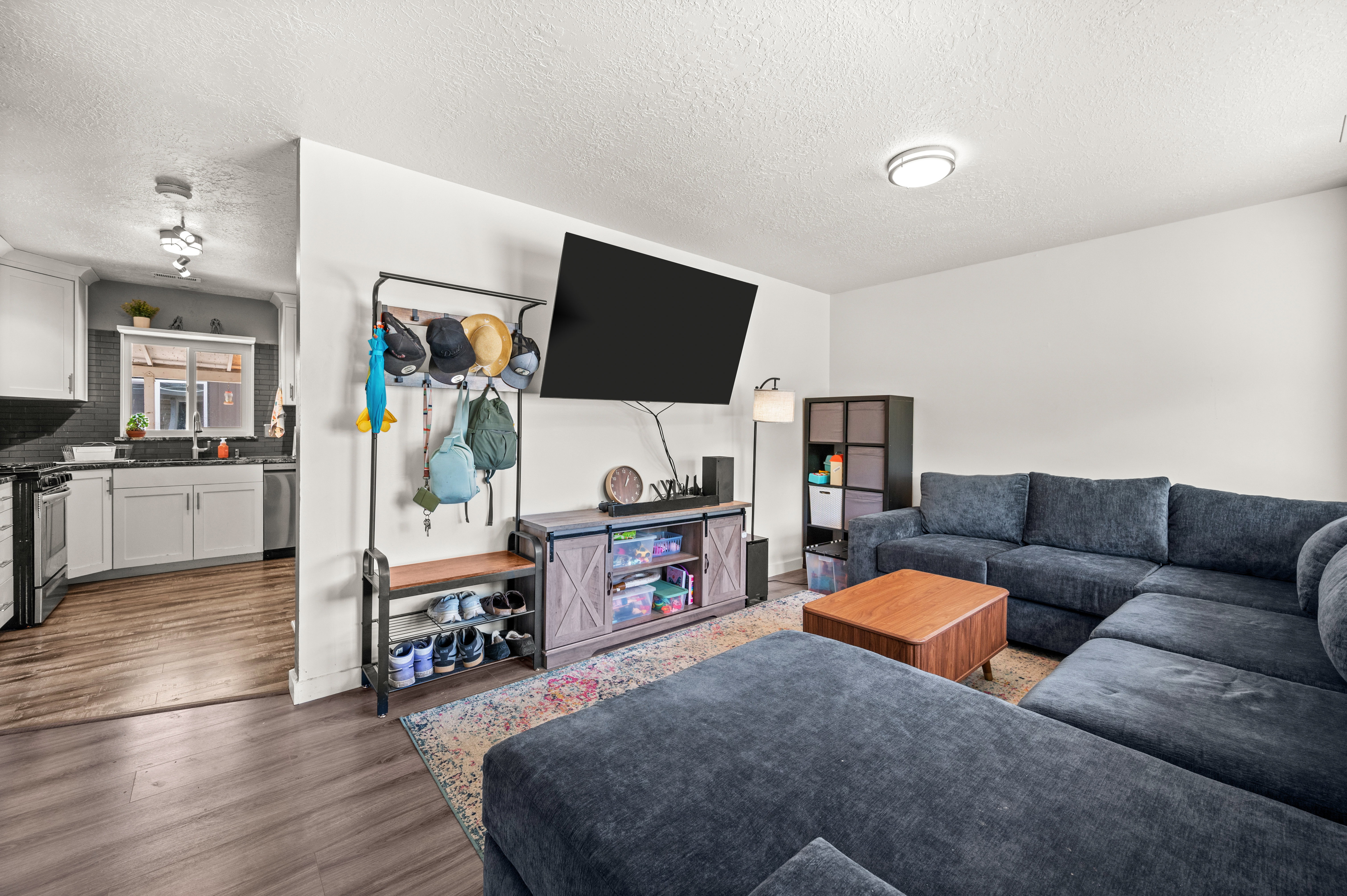 Open-concept living space featuring wood-finish flooring, white walls, and recessed lighting