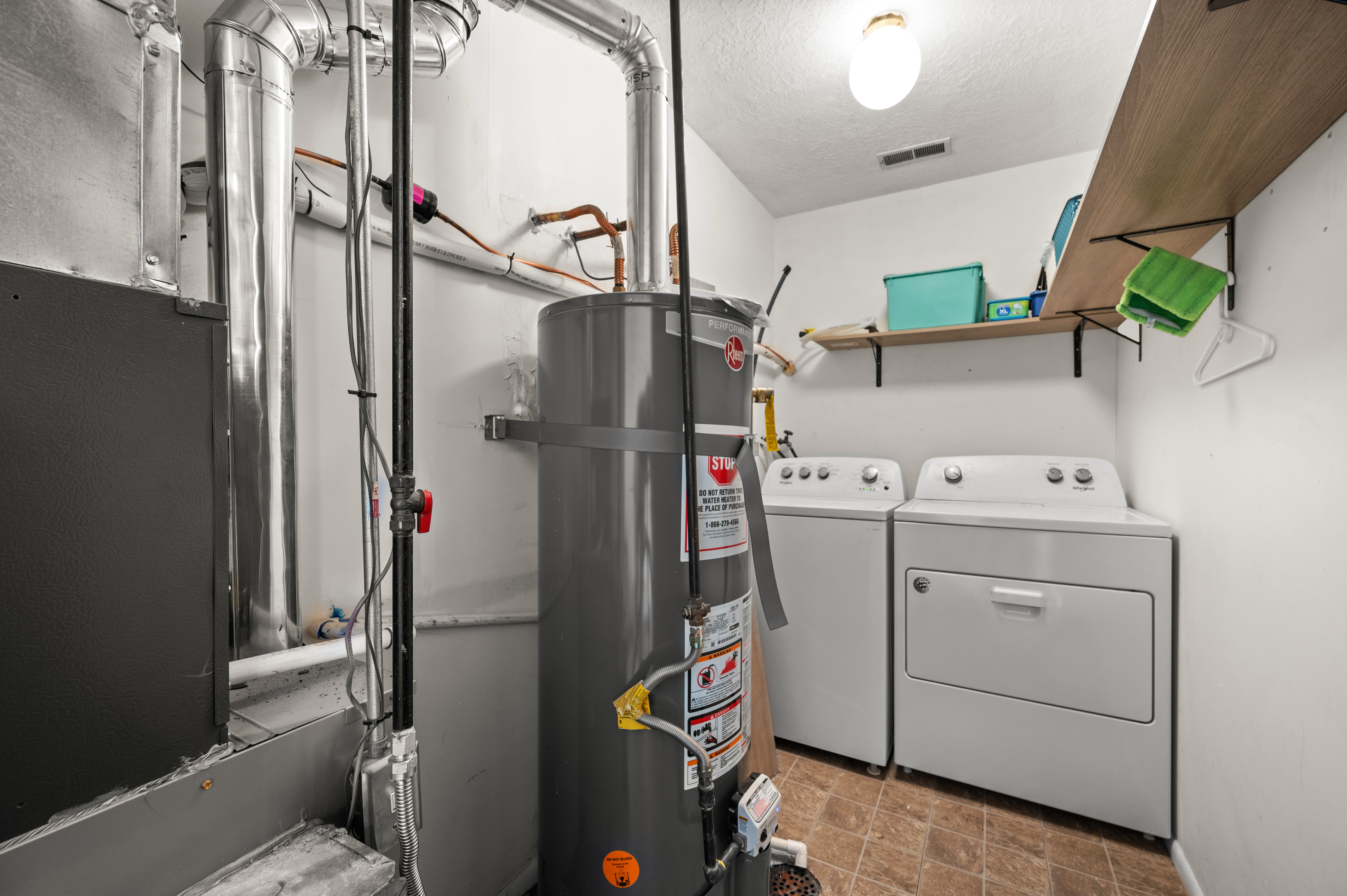 Dedicated utility area featuring a water heater, furnace, and laundry appliances