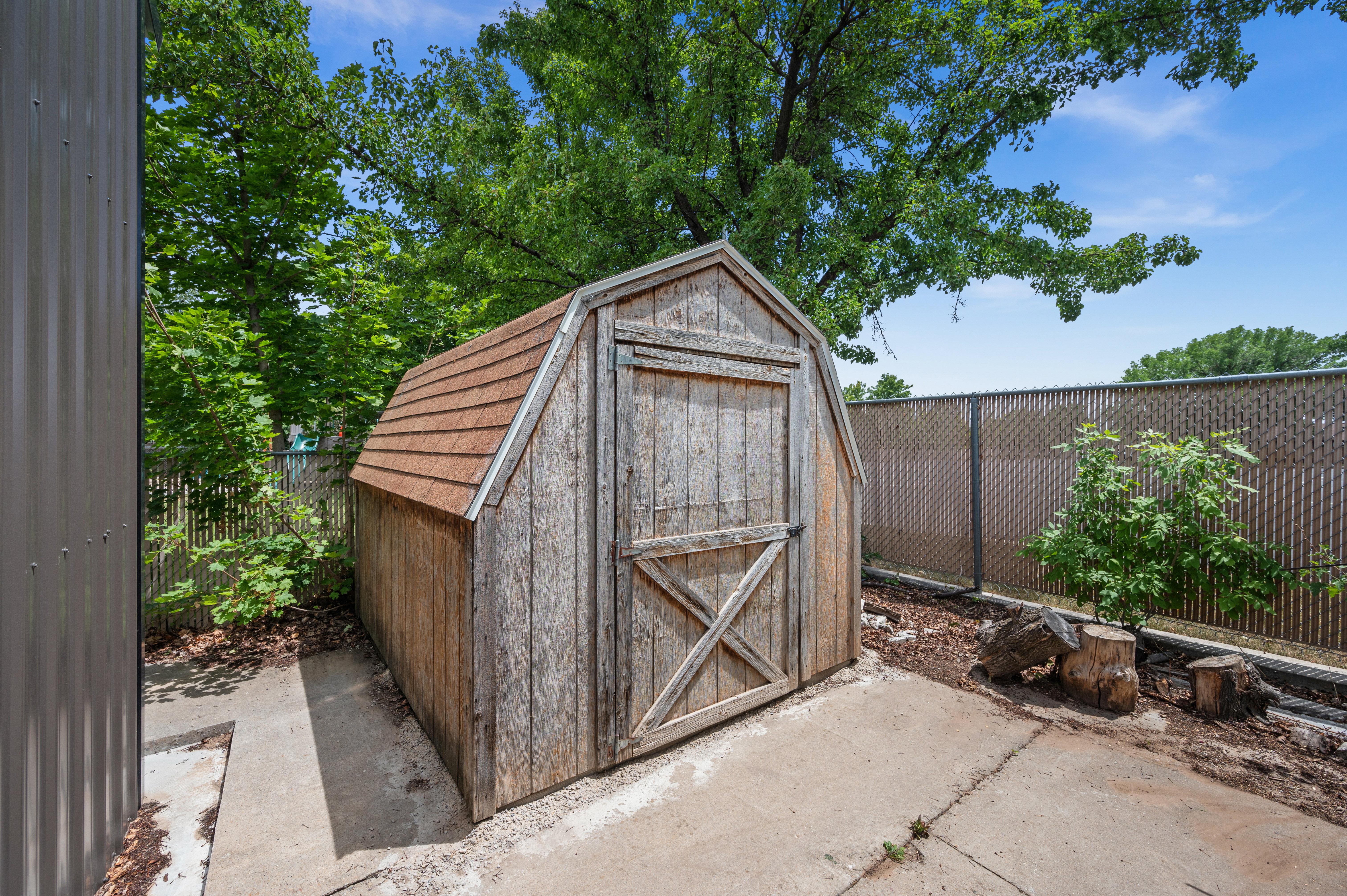 Barn-style storage shed with wood siding and shingle roof