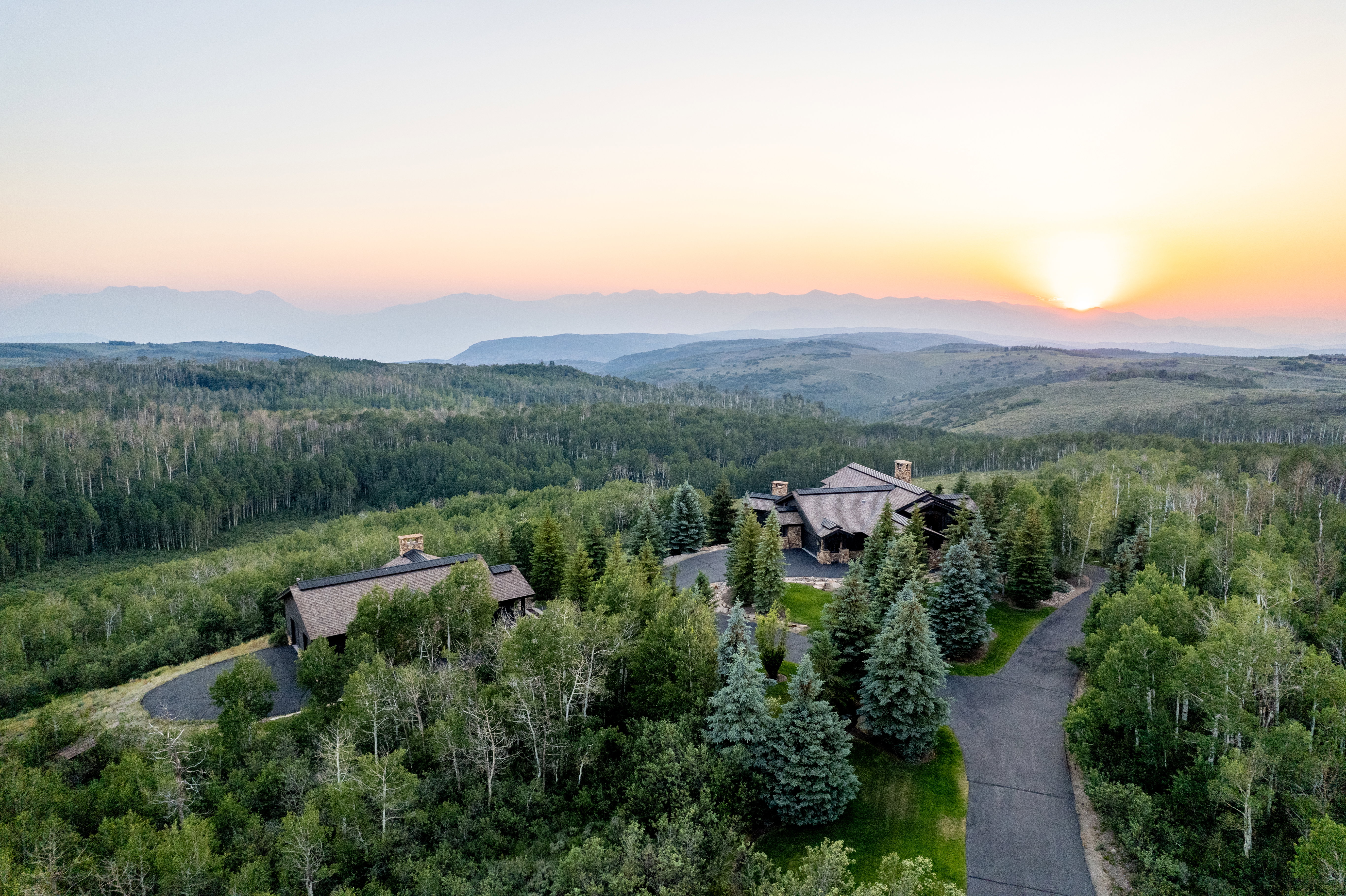 Expansive property featuring two residences amidst a vast, forested landscape