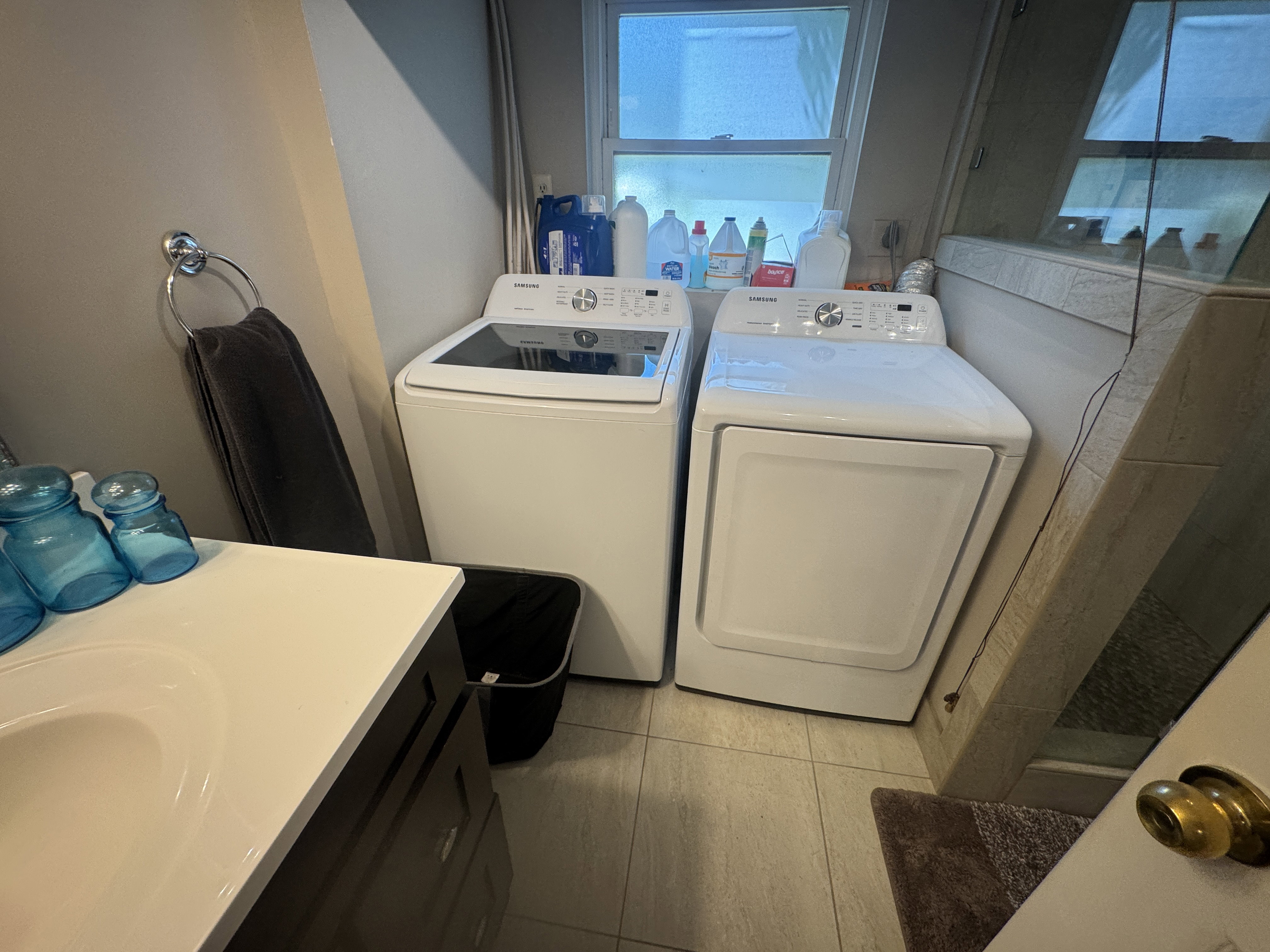 Dedicated laundry area featuring a white top-load washing machine and white front-load dryer