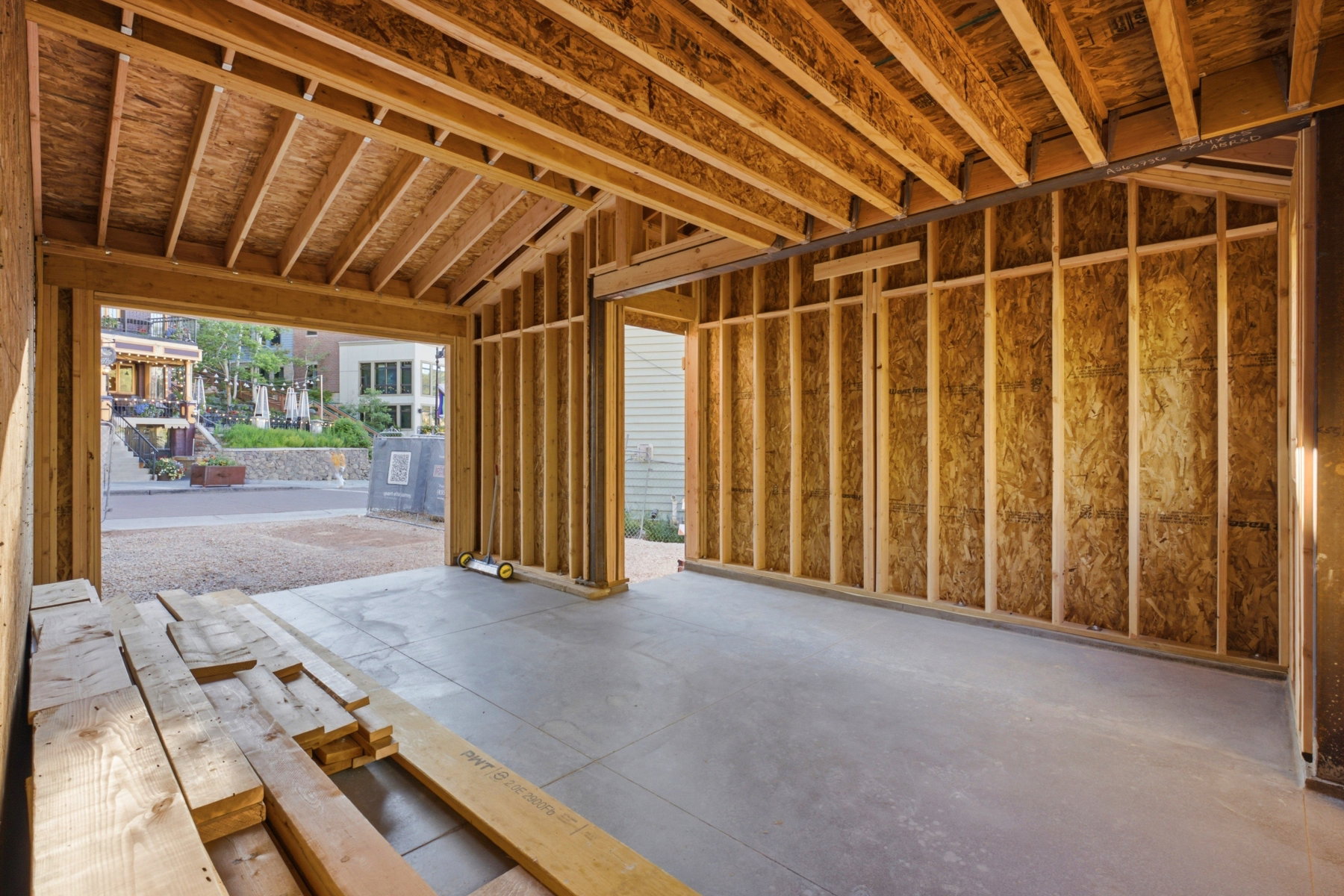 Unfinished two-car garage with exposed wood framing and concrete flooring