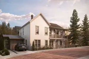 Traditional two-story residence featuring white siding and a prominent front balcony with intricate detailing