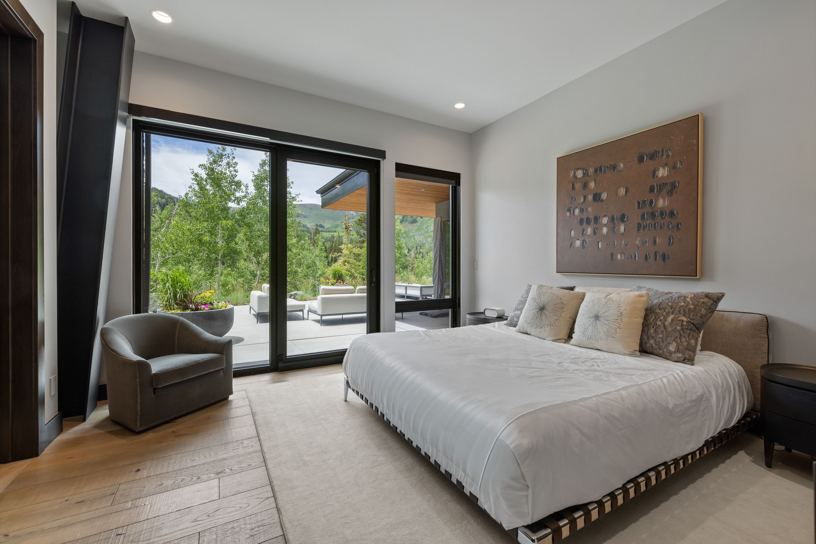 Bedroom featuring large sliding glass doors, light wood-finish flooring, a neutral color palette, recessed lighting, and direct patio access