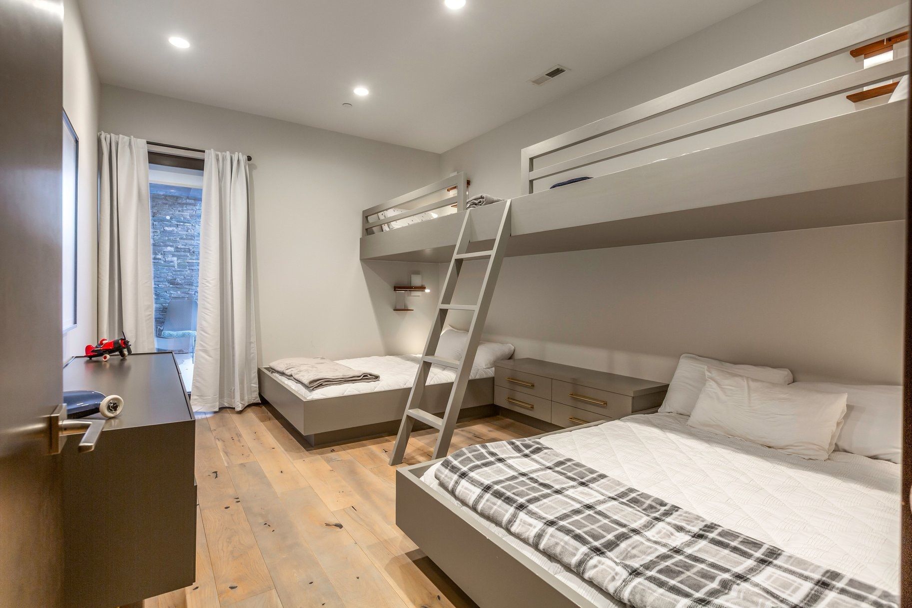 Bedroom featuring a custom built-in bunk bed system with integrated shelving and lighting