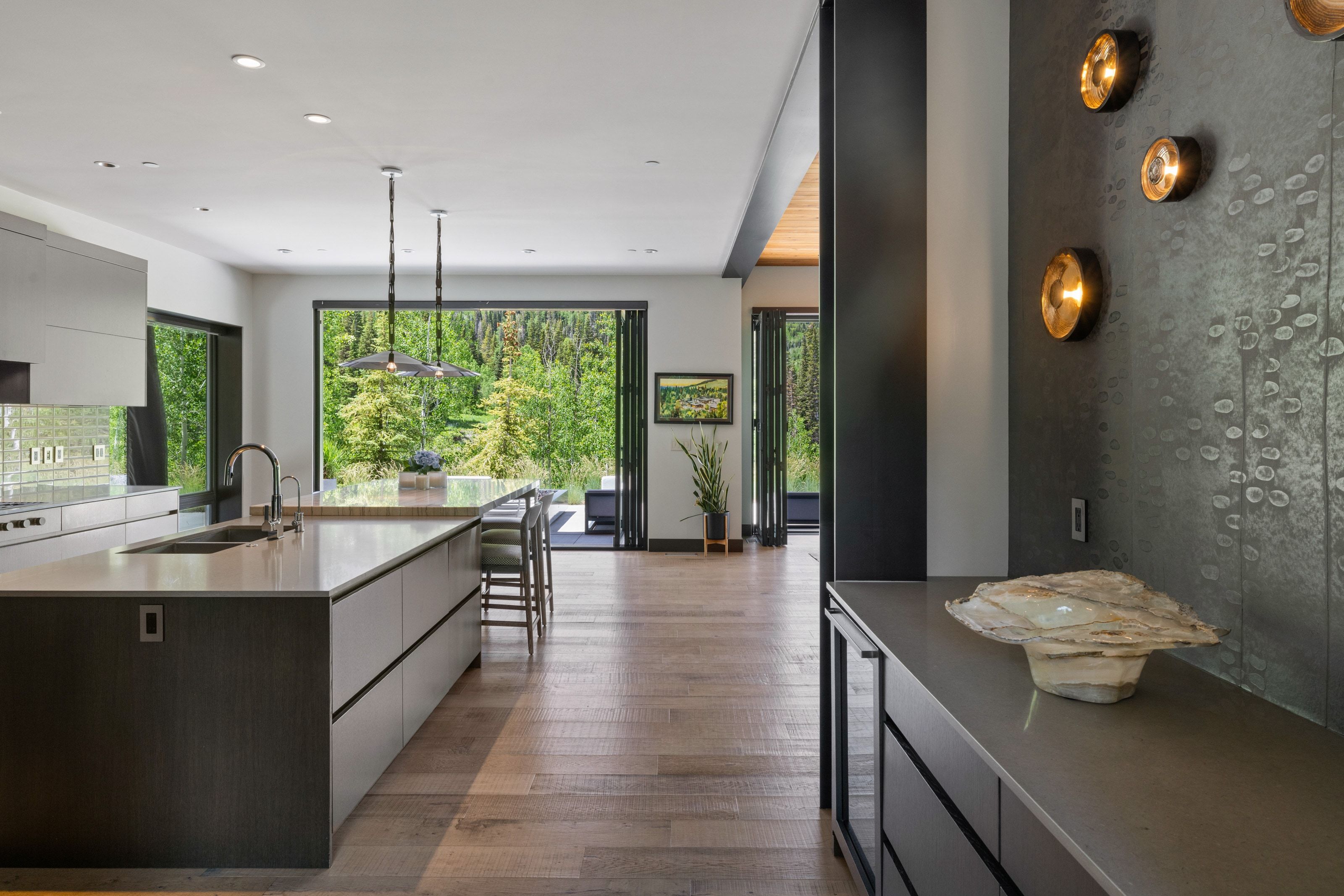Open-concept kitchen featuring an oversized island with dual sinks and pendant lighting