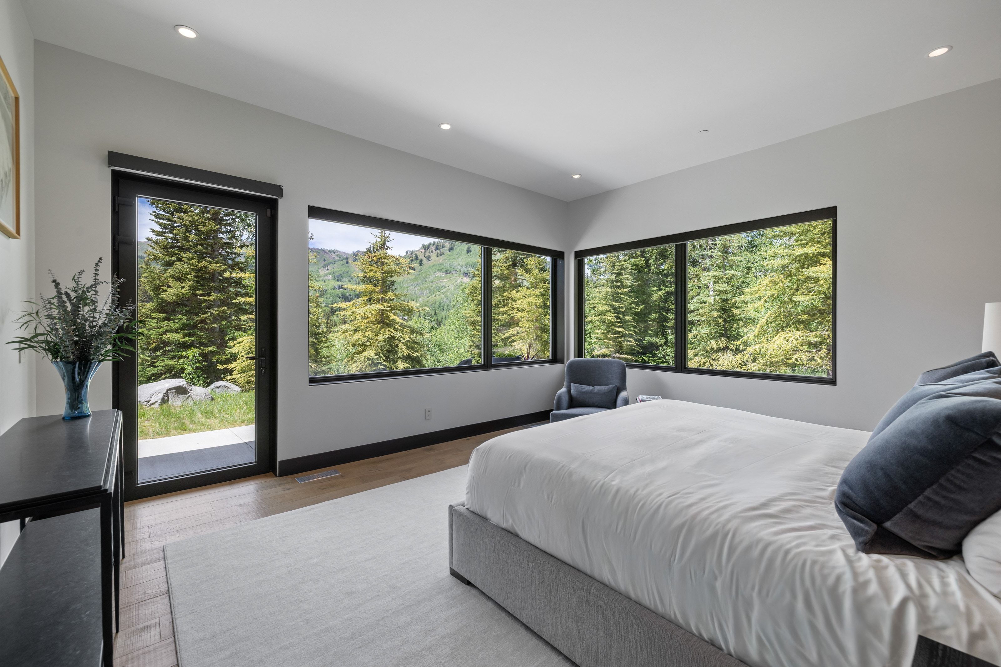 Bright room featuring multiple large windows and a glass-paneled exterior door with black frames