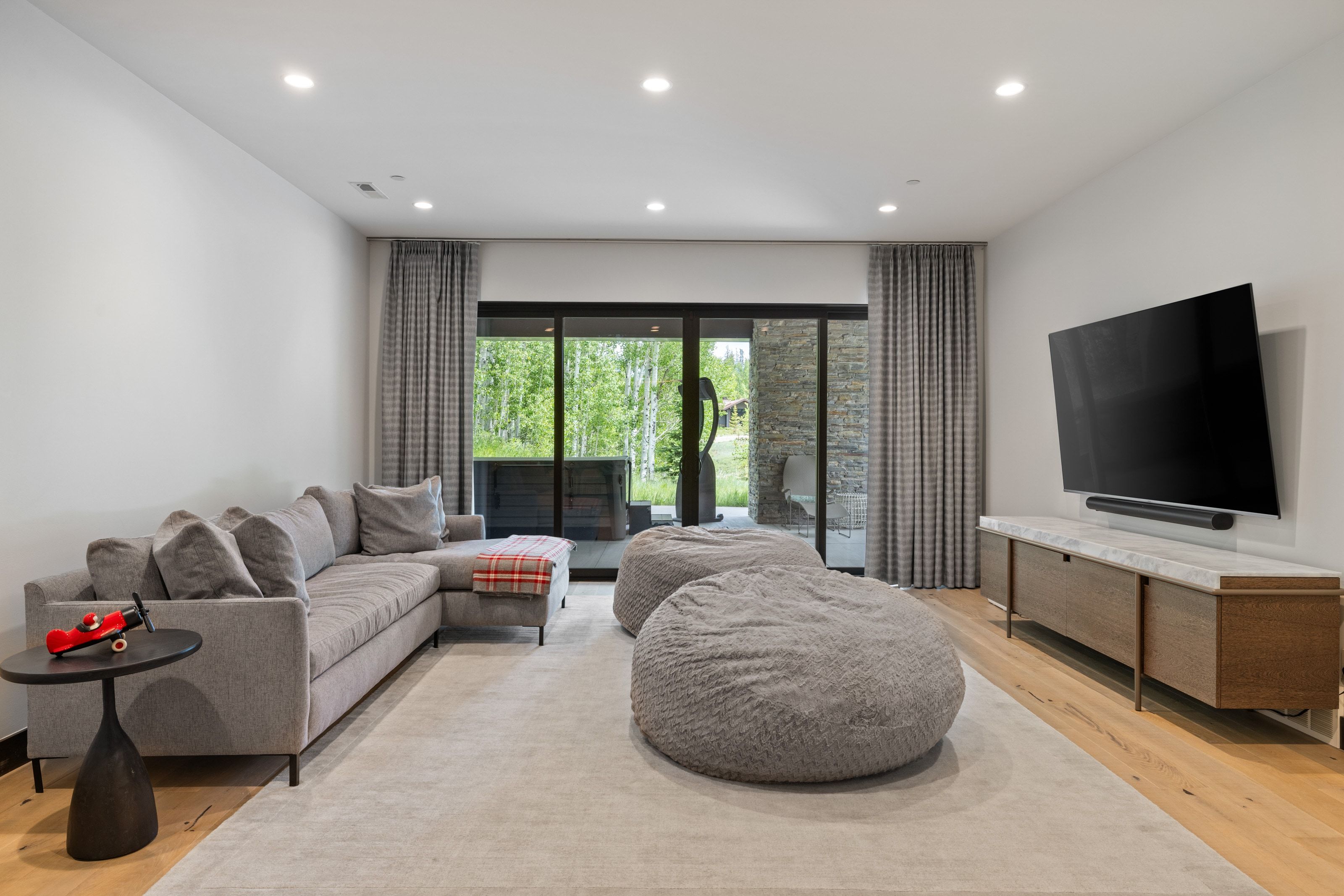 Media room featuring wood-finish flooring, recessed lighting, and a wall-mounted media console with a light-toned countertop