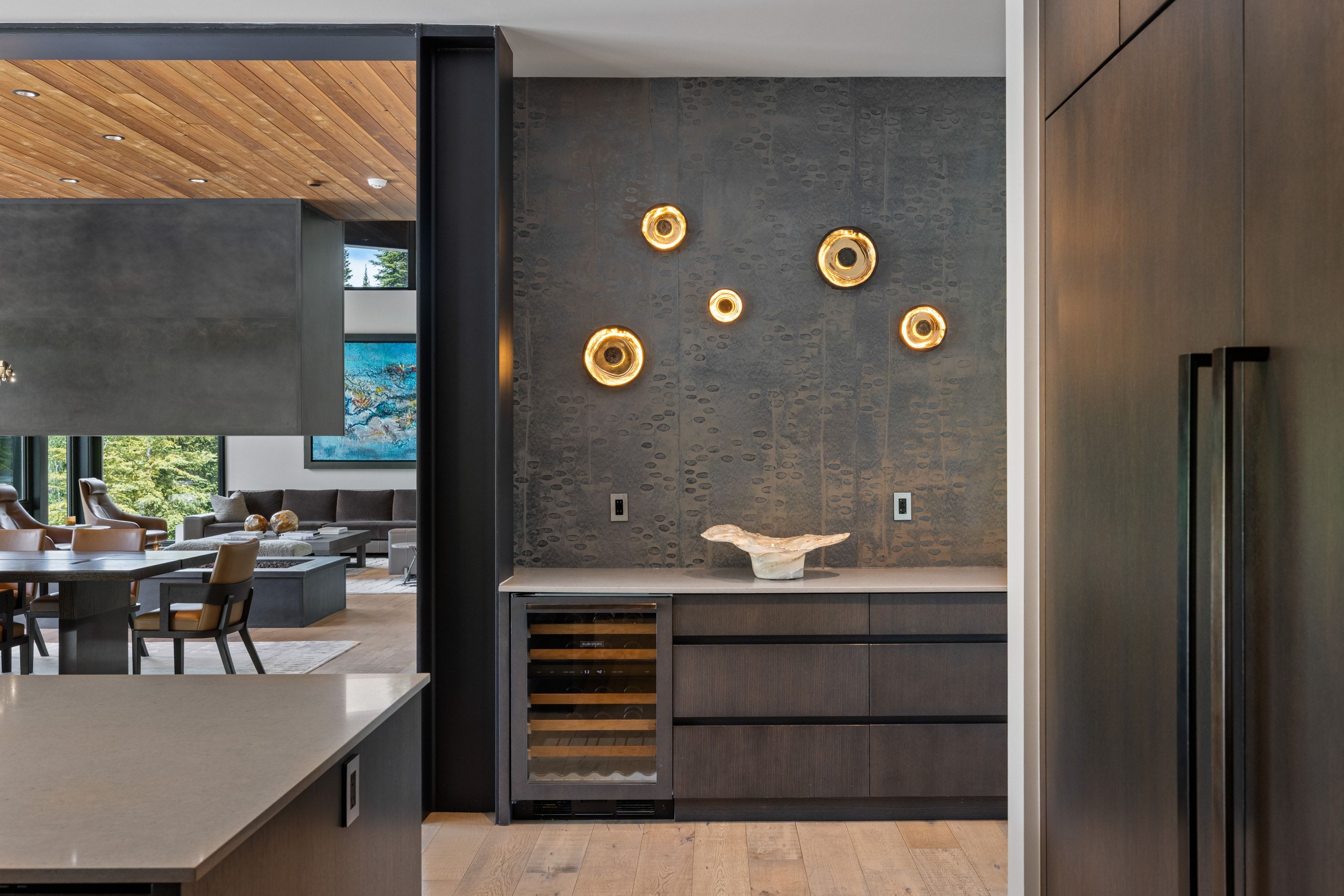 Wet bar featuring a built-in wine refrigerator, dark wood-finish cabinetry, and light countertop