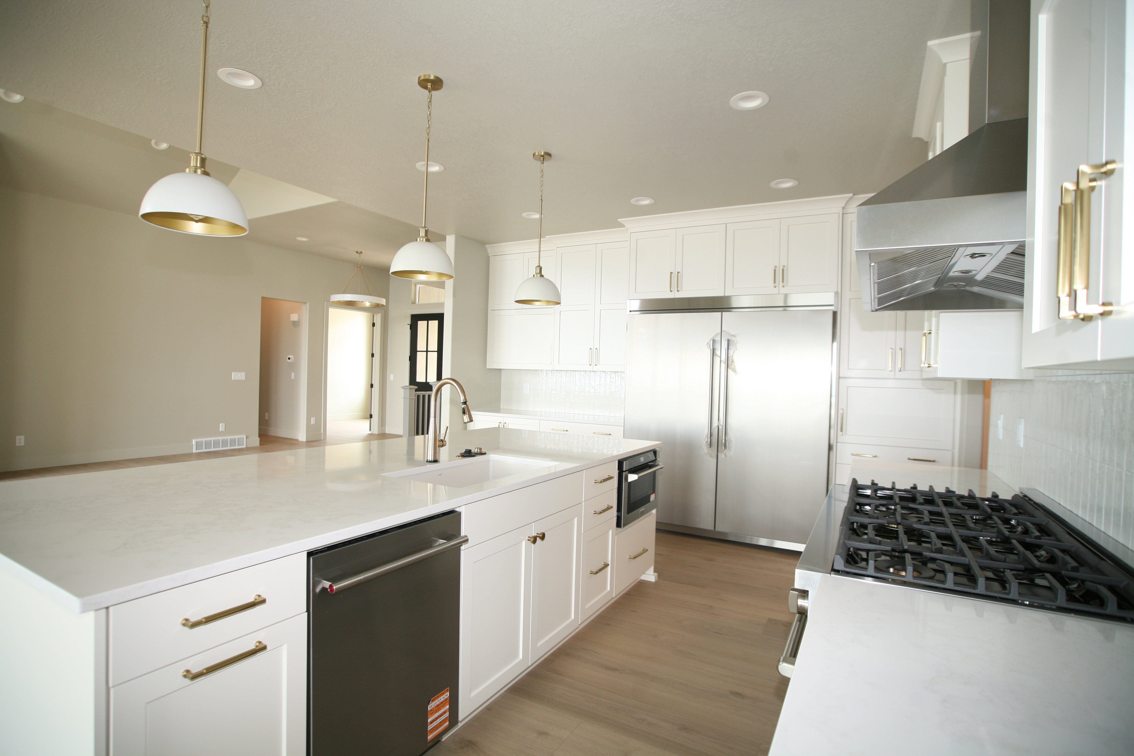 Kitchen featuring white cabinetry with gold-finish hardware, stainless steel appliances, and a gas range