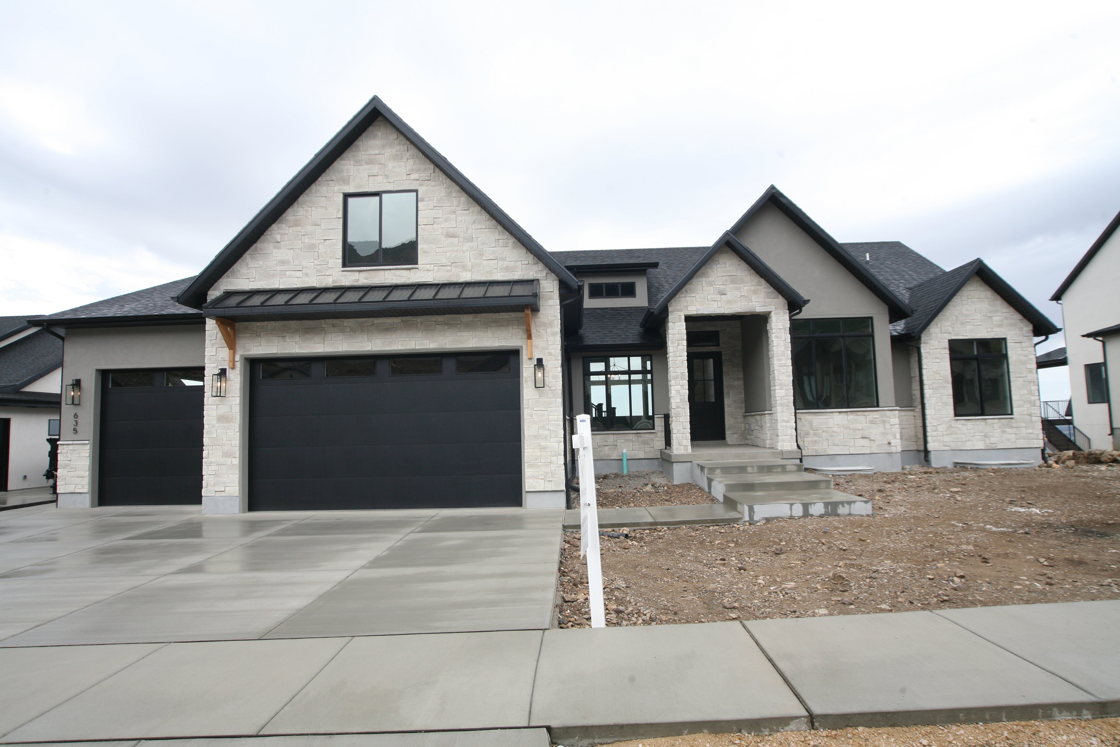 Modern architecture featuring a light stone facade and dark trim accents