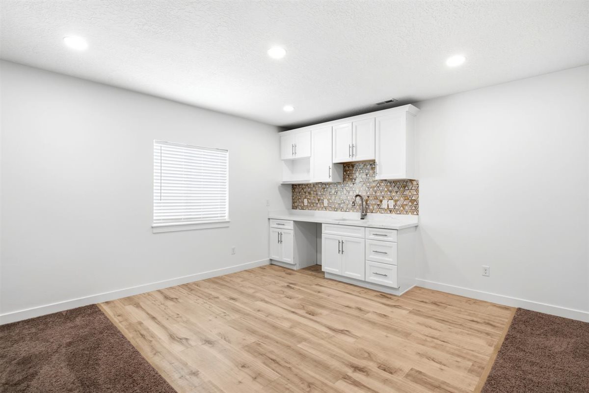 Kitchenette in basement with area for MiniFridge and Microwave. Touches Faucett