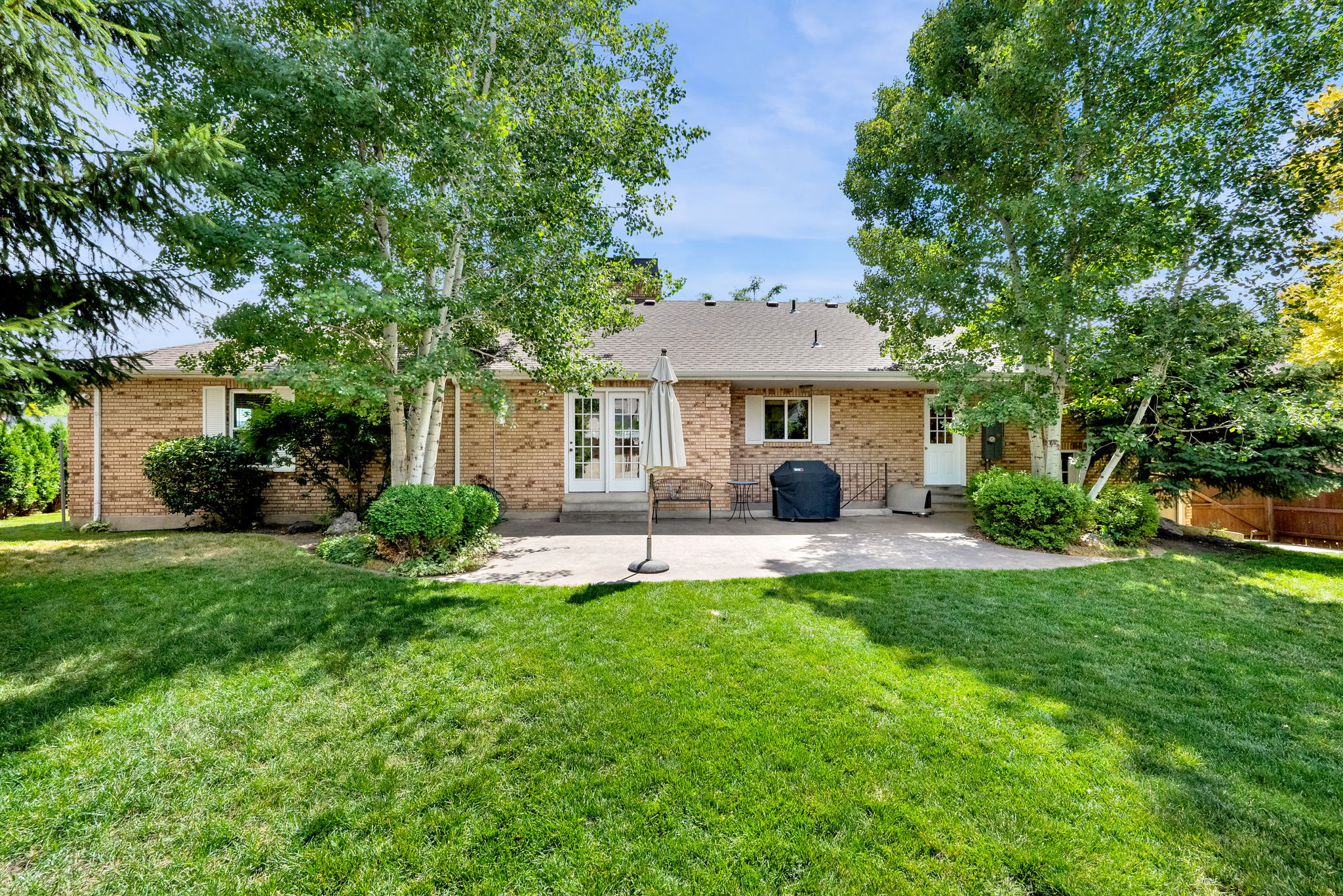 Expansive backyard featuring a large patio, and mature trees