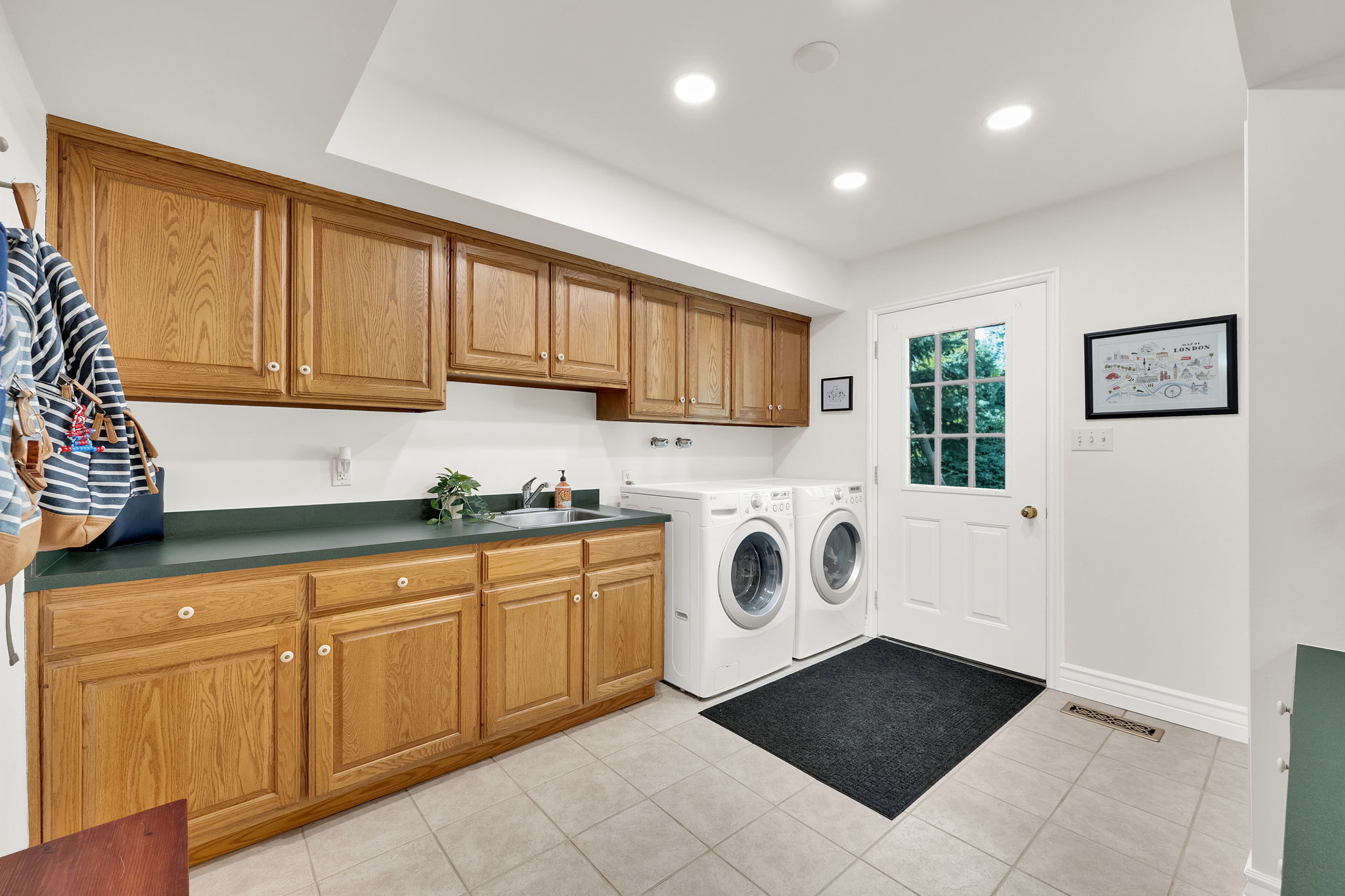 Huge laundry room with sink, cabinets walk door to backyard to double as a mud room