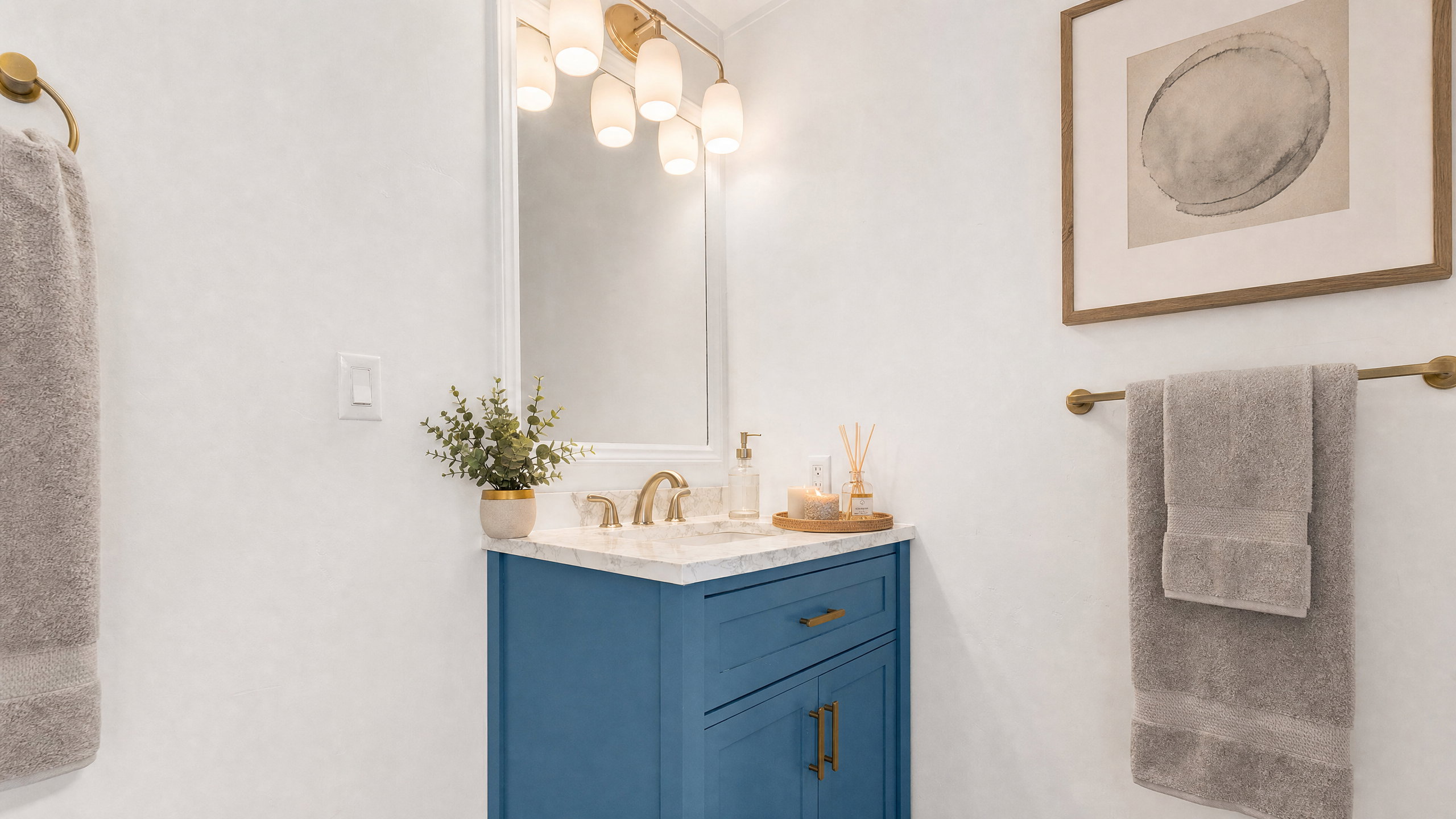 Bathroom vanity featuring a blue base cabinet with brass hardware, a white countertop, and a rectangular mirror