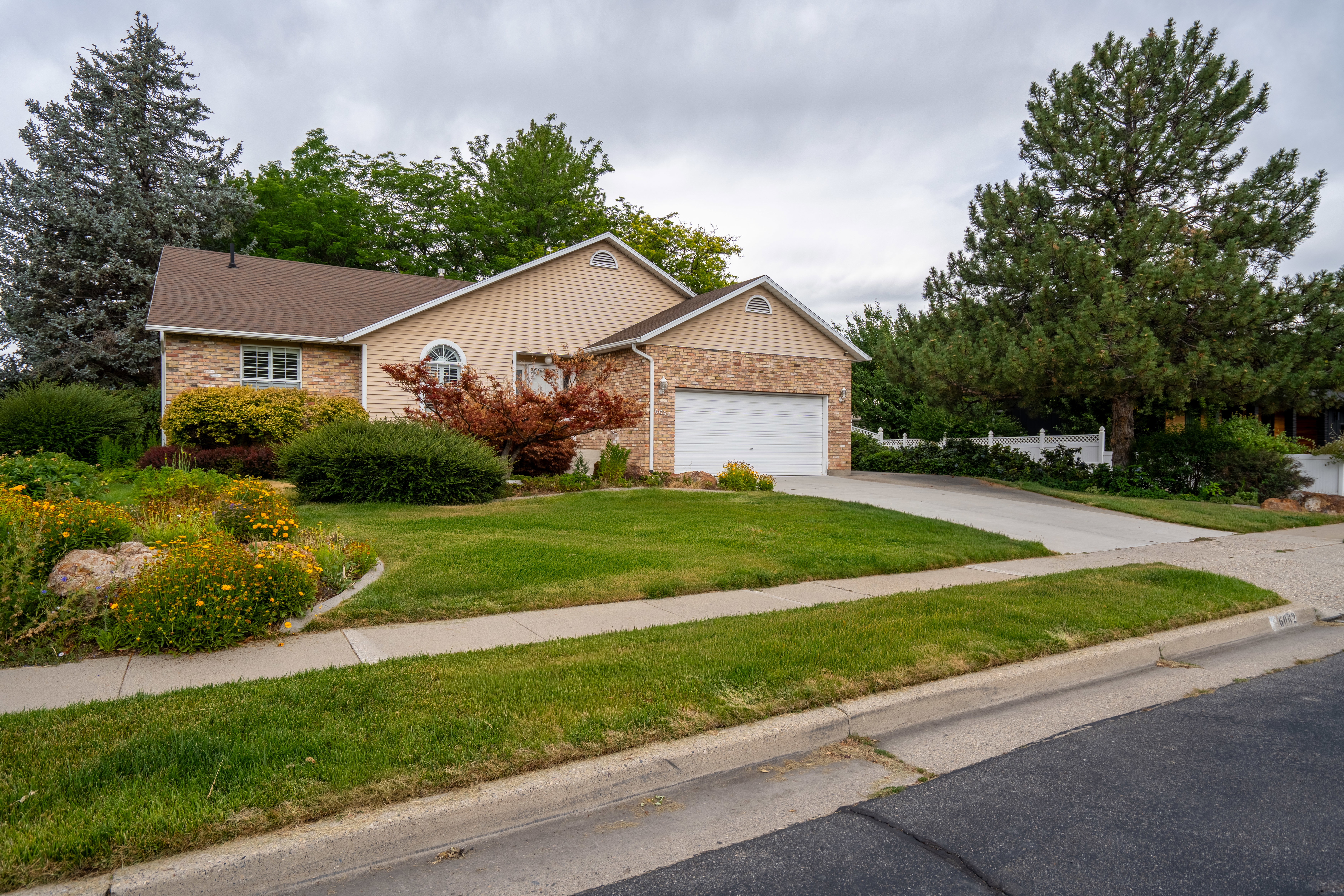 Brick and siding exterior featuring an attached two-car garage