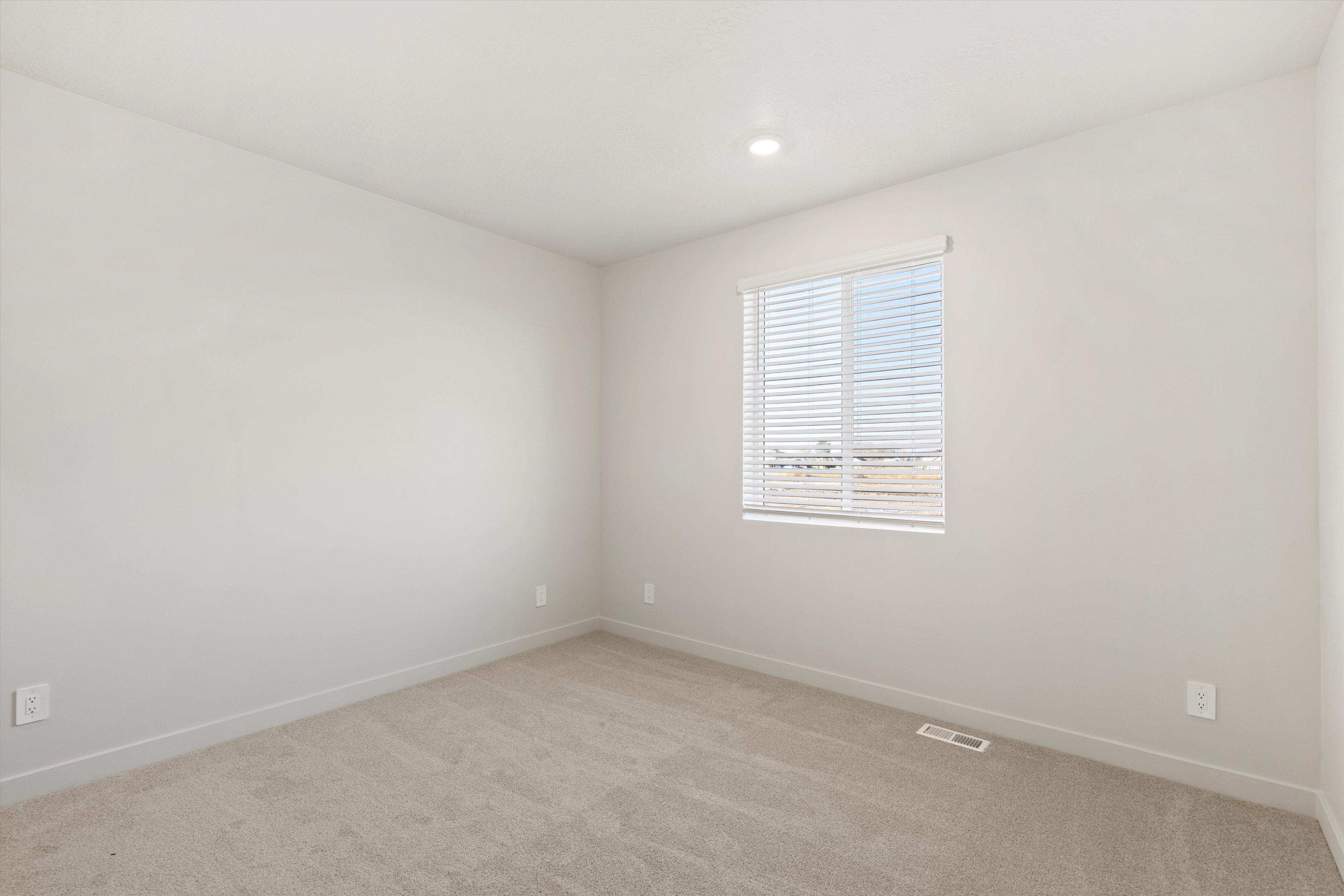 Carpeted room with a single window featuring horizontal blinds
