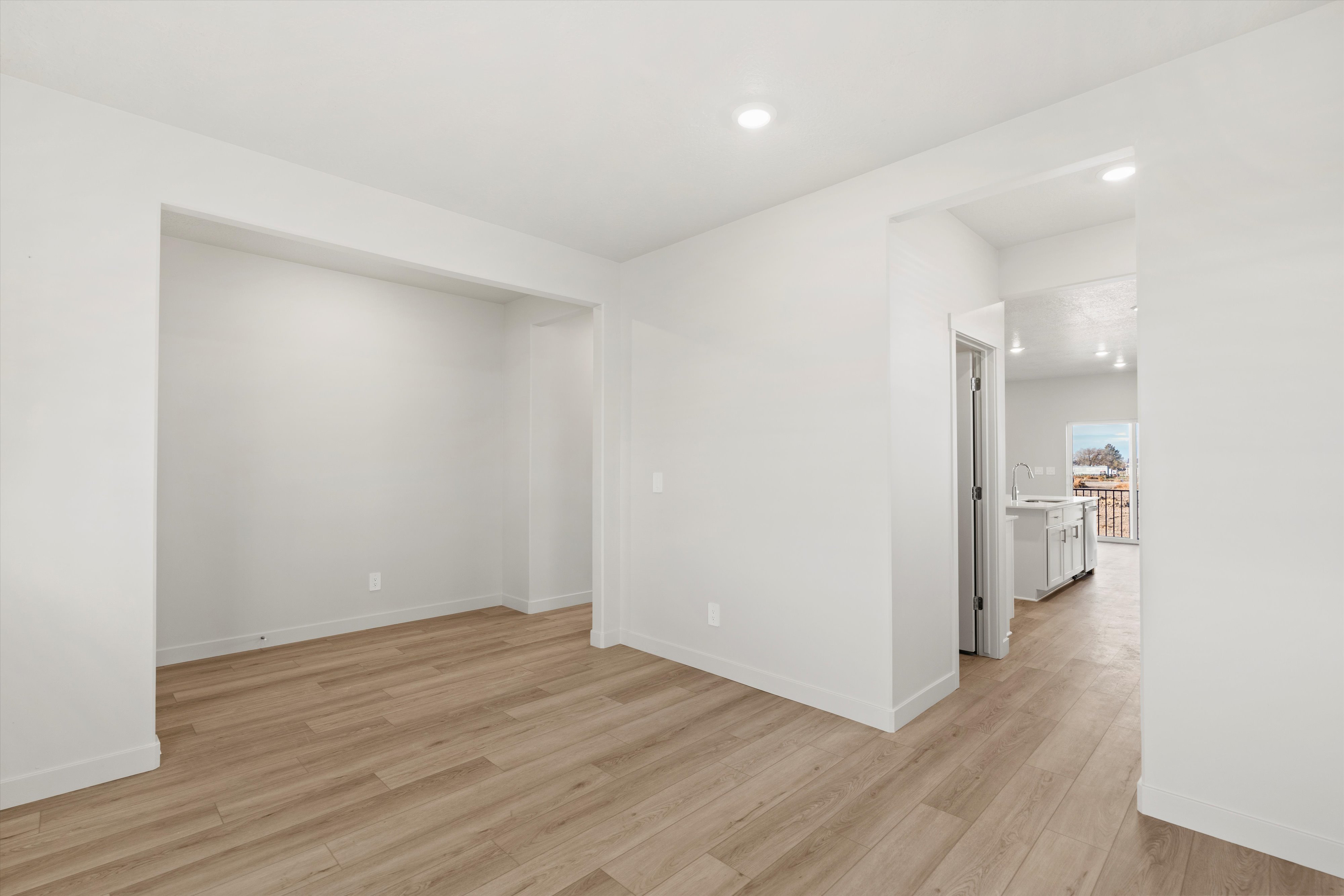 Spacious interior featuring light wood-finish flooring, recessed lighting, and white walls