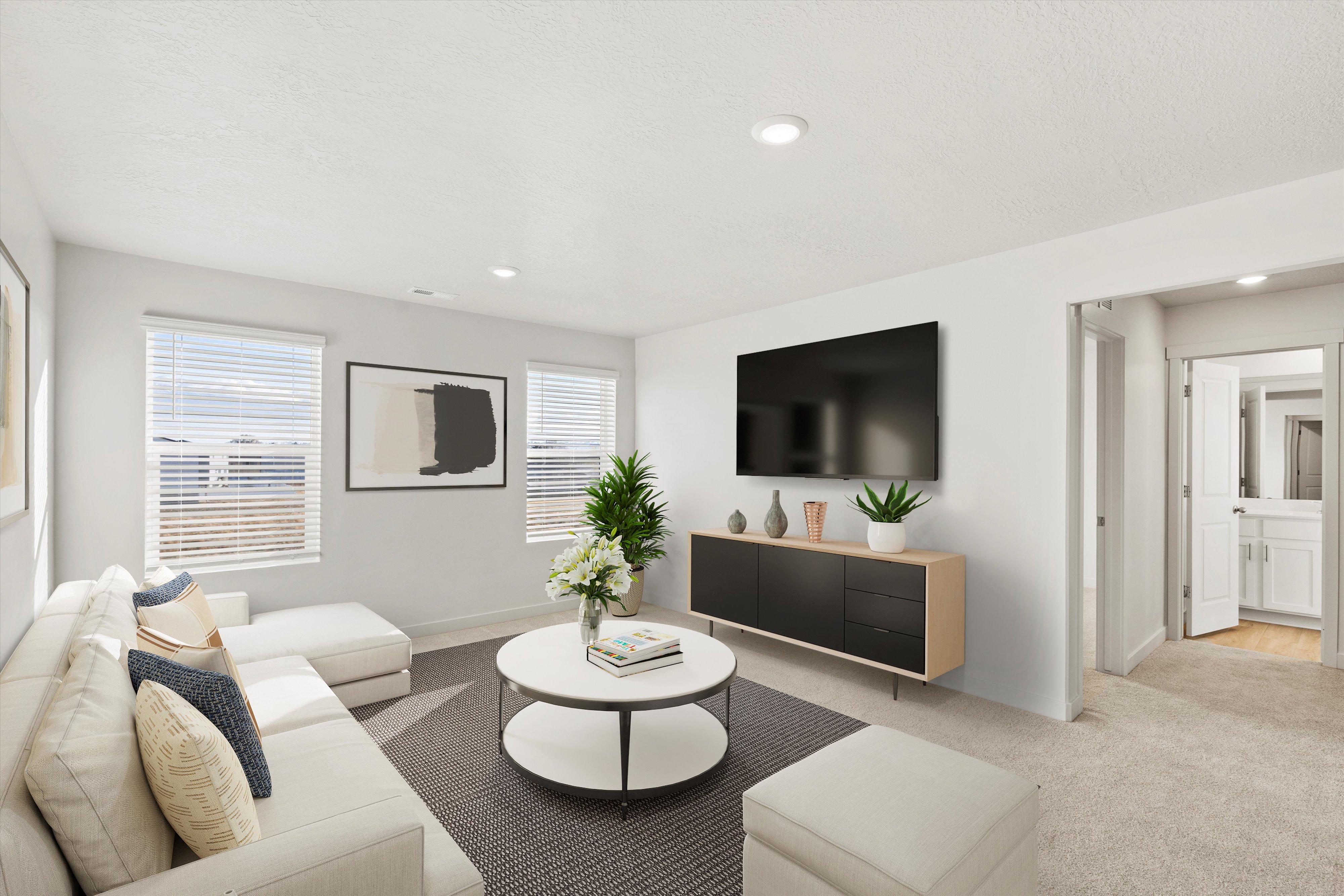 Bright living area featuring white walls and recessed lighting
