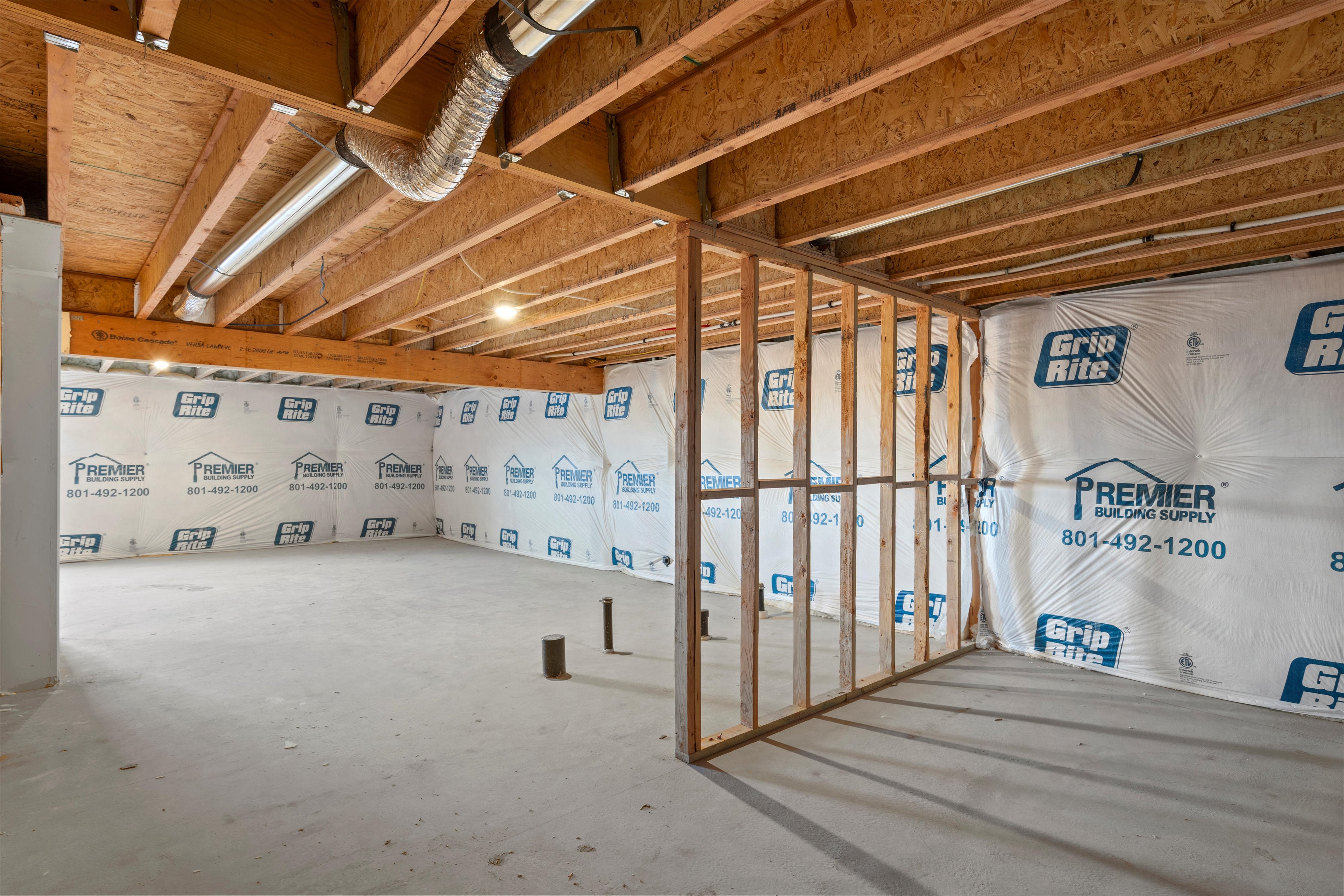 Unfinished basement space featuring exposed wood joists and subfloor
